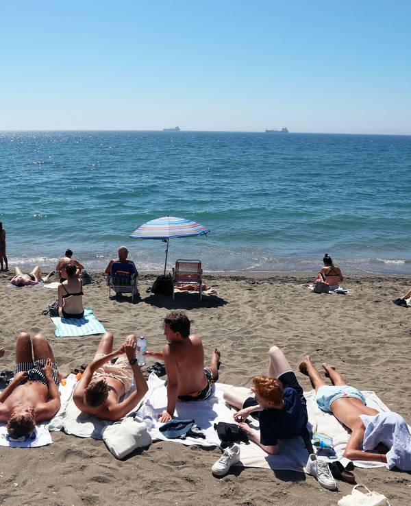 Urlauberinnen und Urlauber sonnen sich am Strand von La Malagueta.