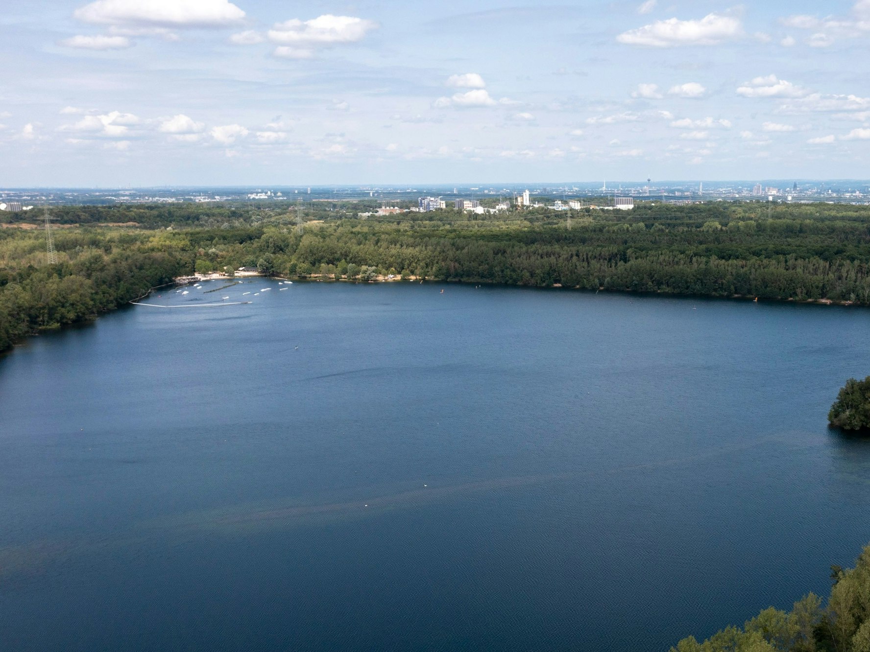 Ein See mit blauem Wasser vor einem Stadtpanorama