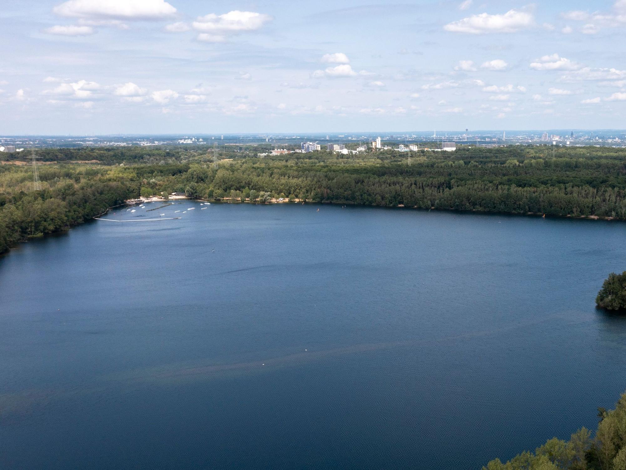 Ein See mit blauem Wasser vor einem Stadtpanorama