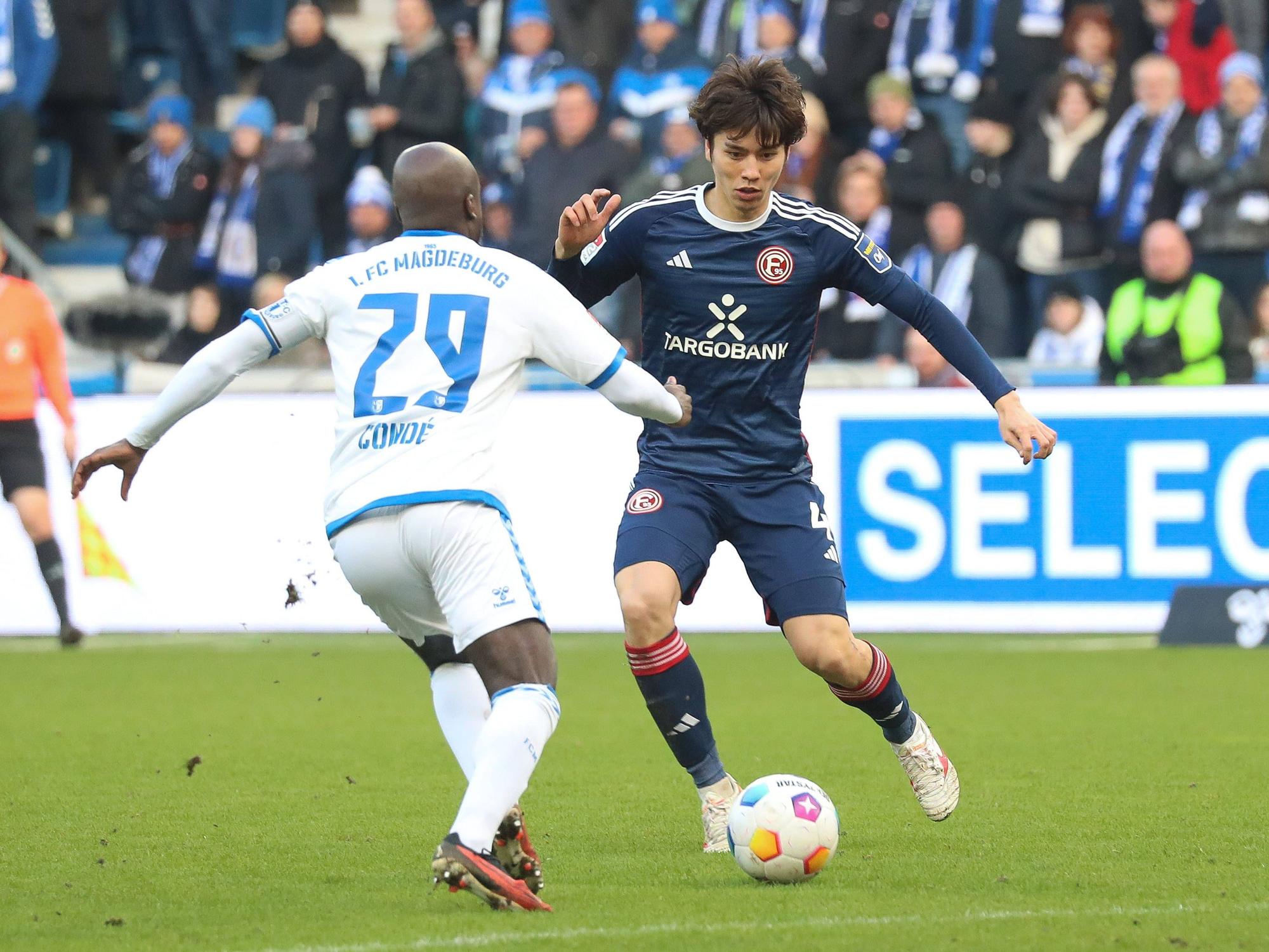 Fortuna Düsseldorfs Ao Tanaka und Magdeburgs Amara Condé kämpfen um den Ball.
