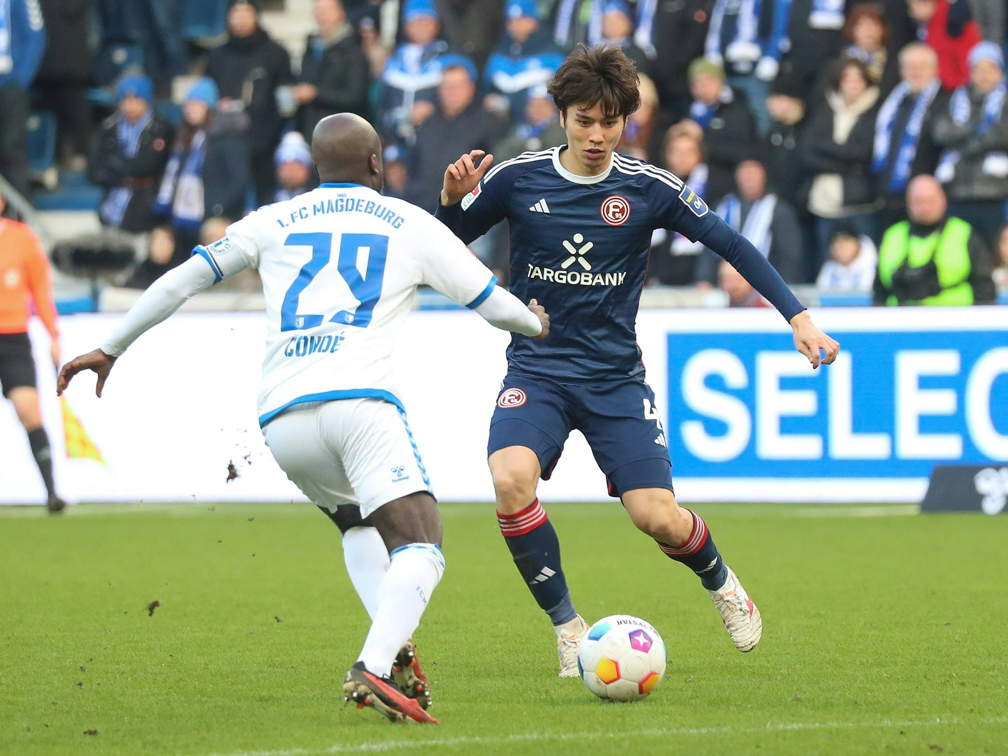 Fortuna Düsseldorfs Ao Tanaka und Magdeburgs Amara Condé kämpfen um den Ball.