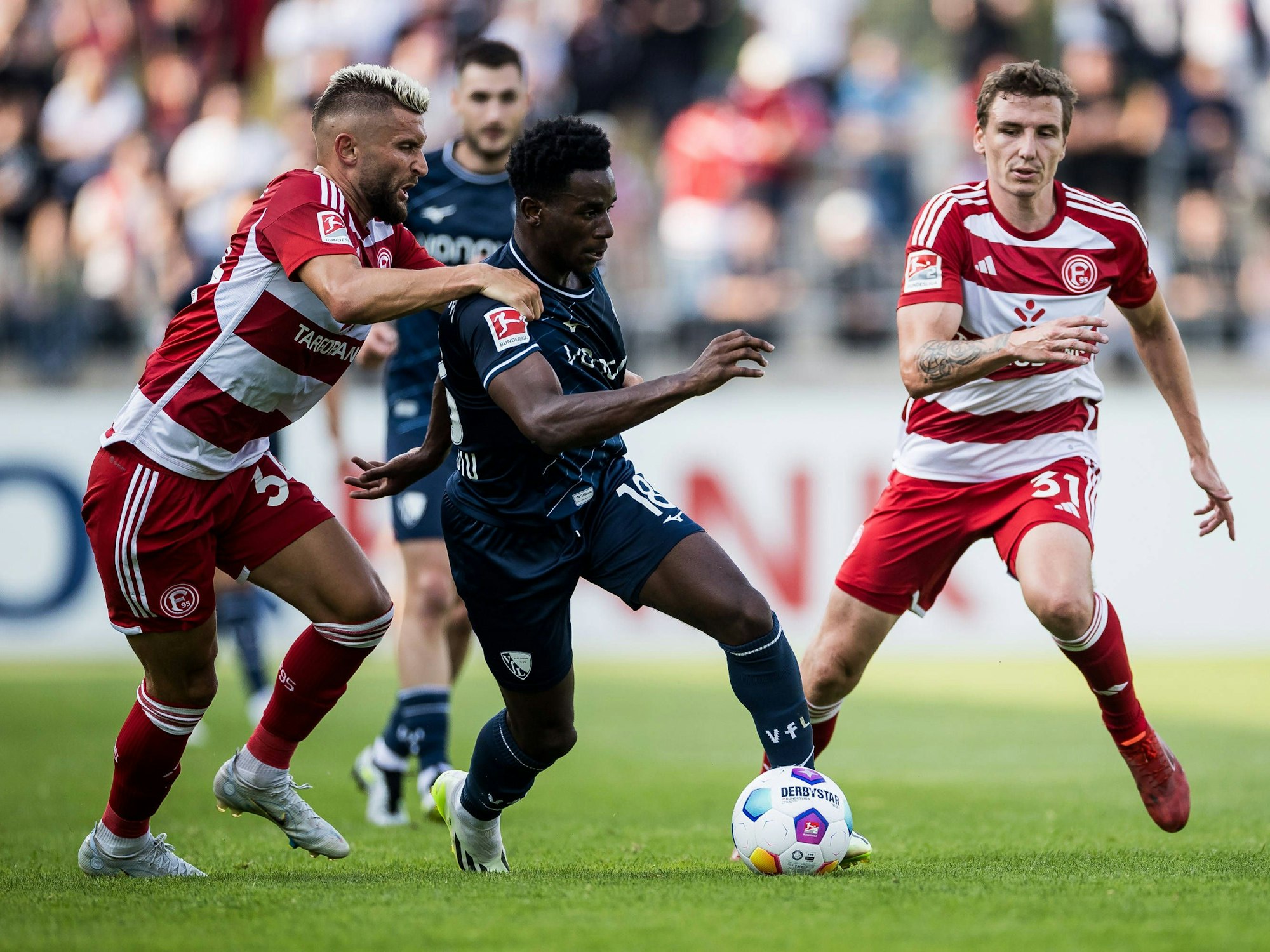Fortuna Düsseldorf Spieler im Duell mit VfL Bochum Spielern.