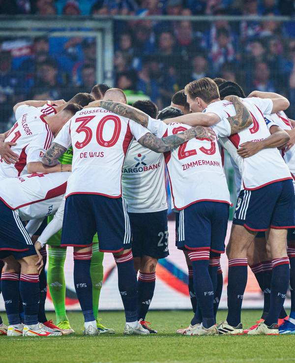 Die Mannschaft von Fortuna Düsseldorf liegt sich für eine Besprechung in den Armen.