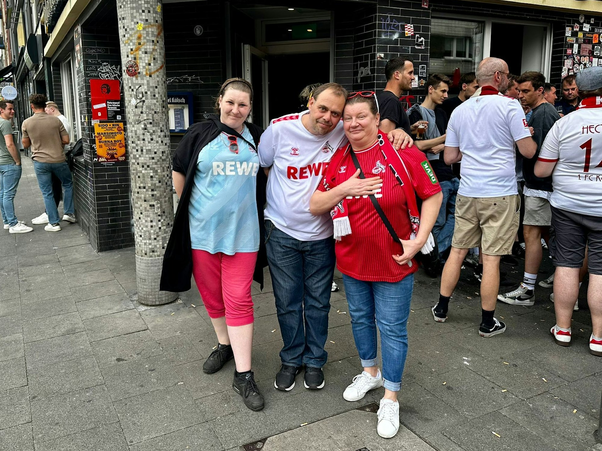 Die FC Fans Manuela, Markus und Simone stehen vor dem Knobelbecher.