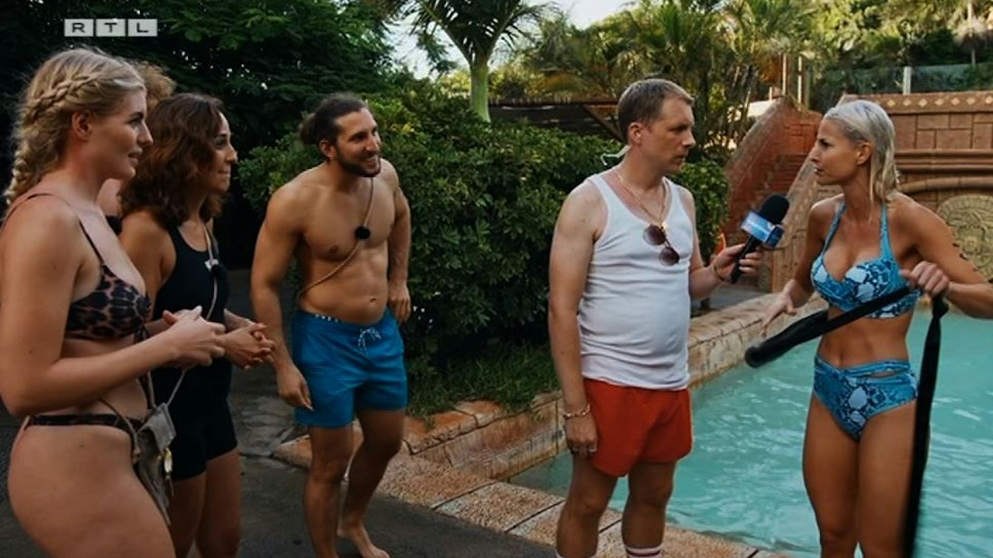 Antonia Hemmer, Nina Moghaddam und Adriano Salvaggio lauschen gespannt den Fragen, die Bademeister Oliver Pocher nach dem Ritt auf der 28-Meter-Rutsche an Isi Glück (v.l.) stellt.