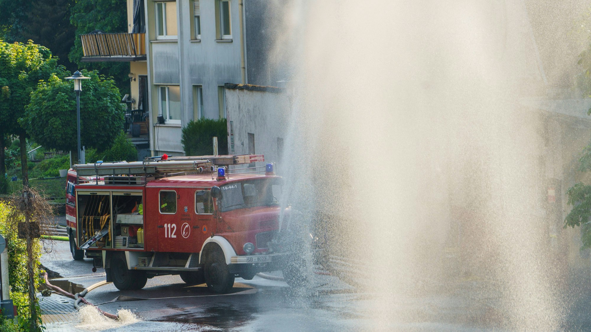 Mit riesigen Wasserfontainen befördert die Feuerwehr das Wasser aus den vollgelaufenen Kellern im Stadtteil Schönbach wieder zurück in die Saar.
