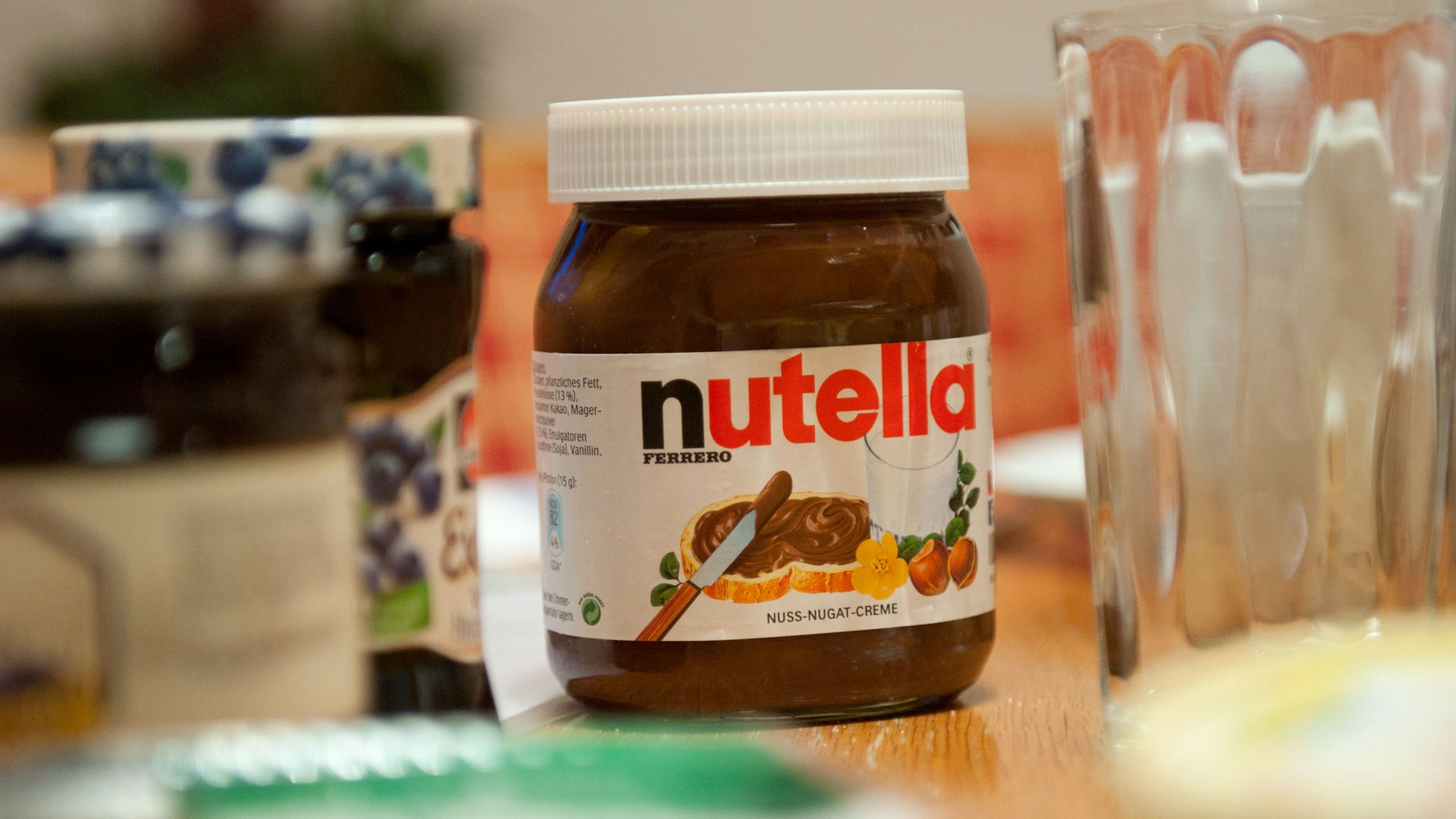Ein Glas Nutella steht auf dem Frühstückstisch.