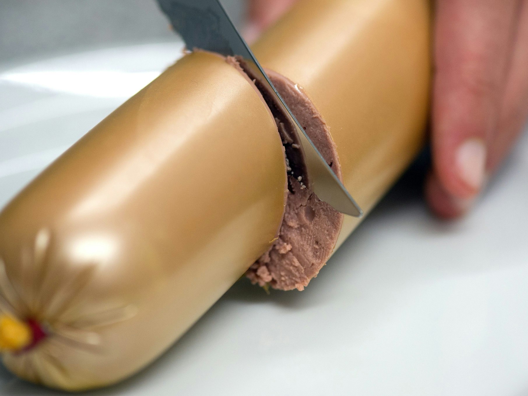 Vor dem Oberverwaltungsgericht wird über die korrekte Füllmenge von Wurstwaren verhandelt. Das Symbolfoto vom 14. Juli 2014 zeigt eine Frau, die eine Leberwurst anschneidet.