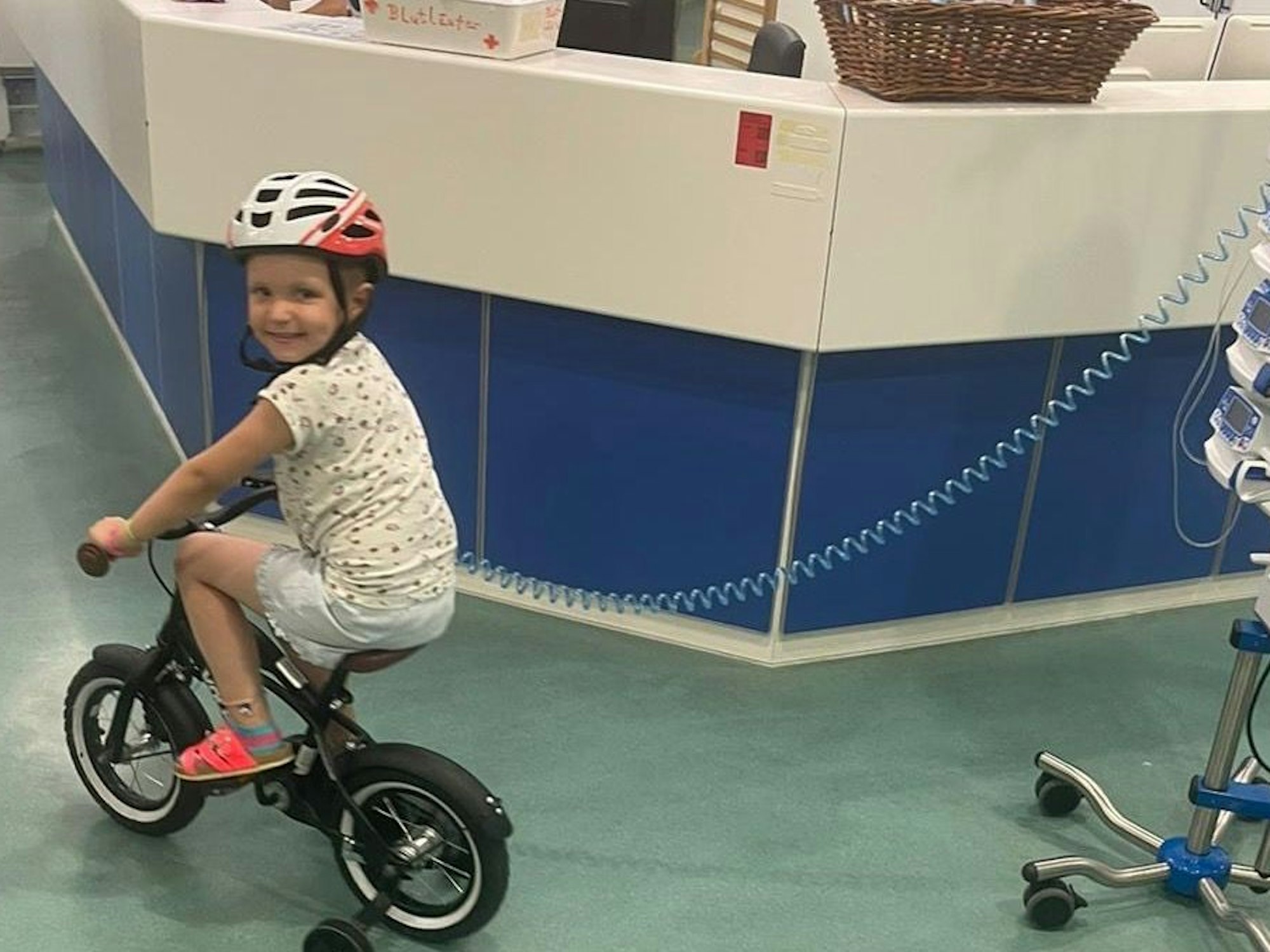 Ein kleines Mädchen fährt im Krankenhaus Fahrrad.