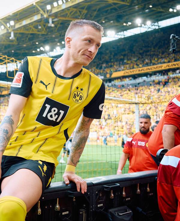 Dortmunds Marco Reus klettert nach dem Spiel über die Bande.