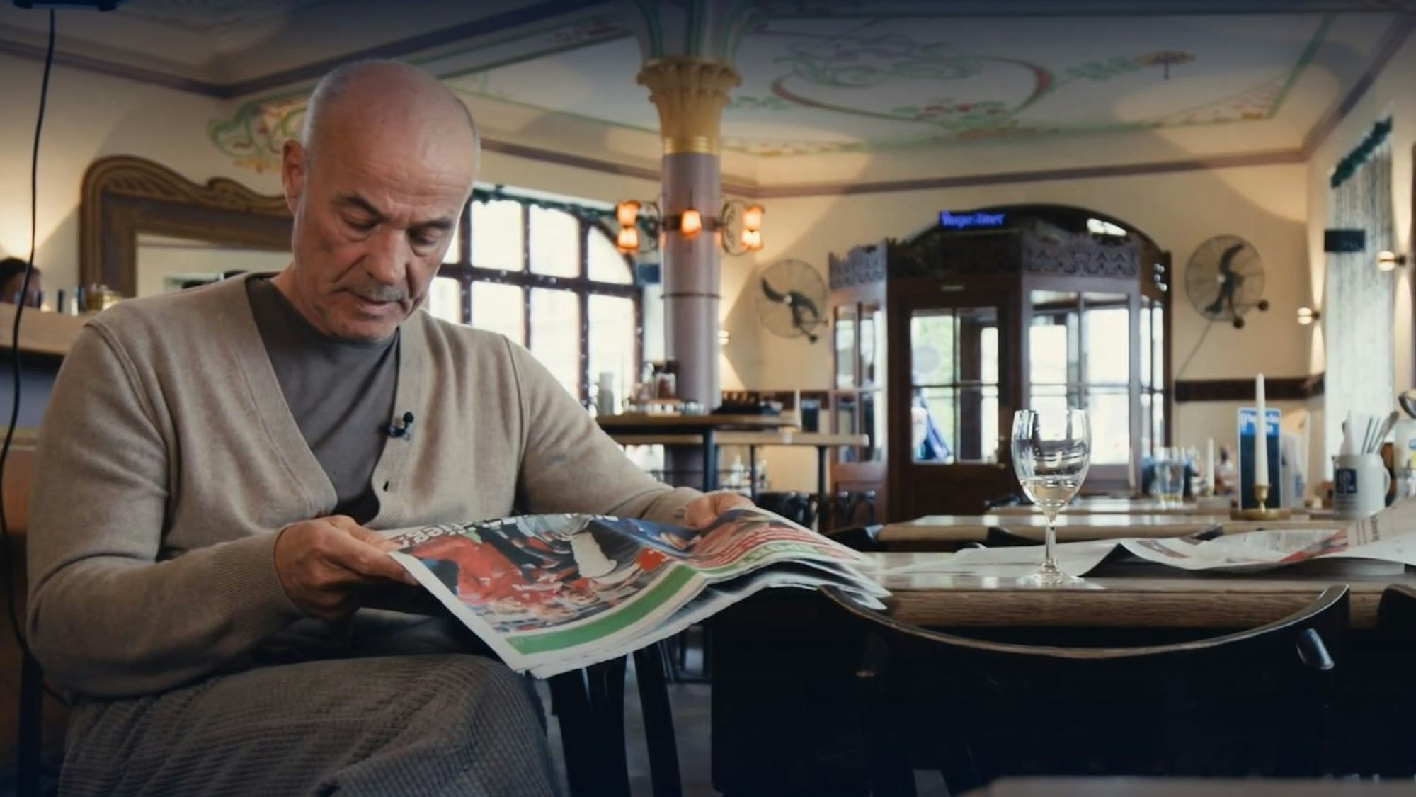 Heiner Lauterbach liest am Rande seines Interviews für die WDR-Doku „Nie mehr Vizekusen“ in einer Gaststätte eine Print-Ausgabe des EXPRESS.