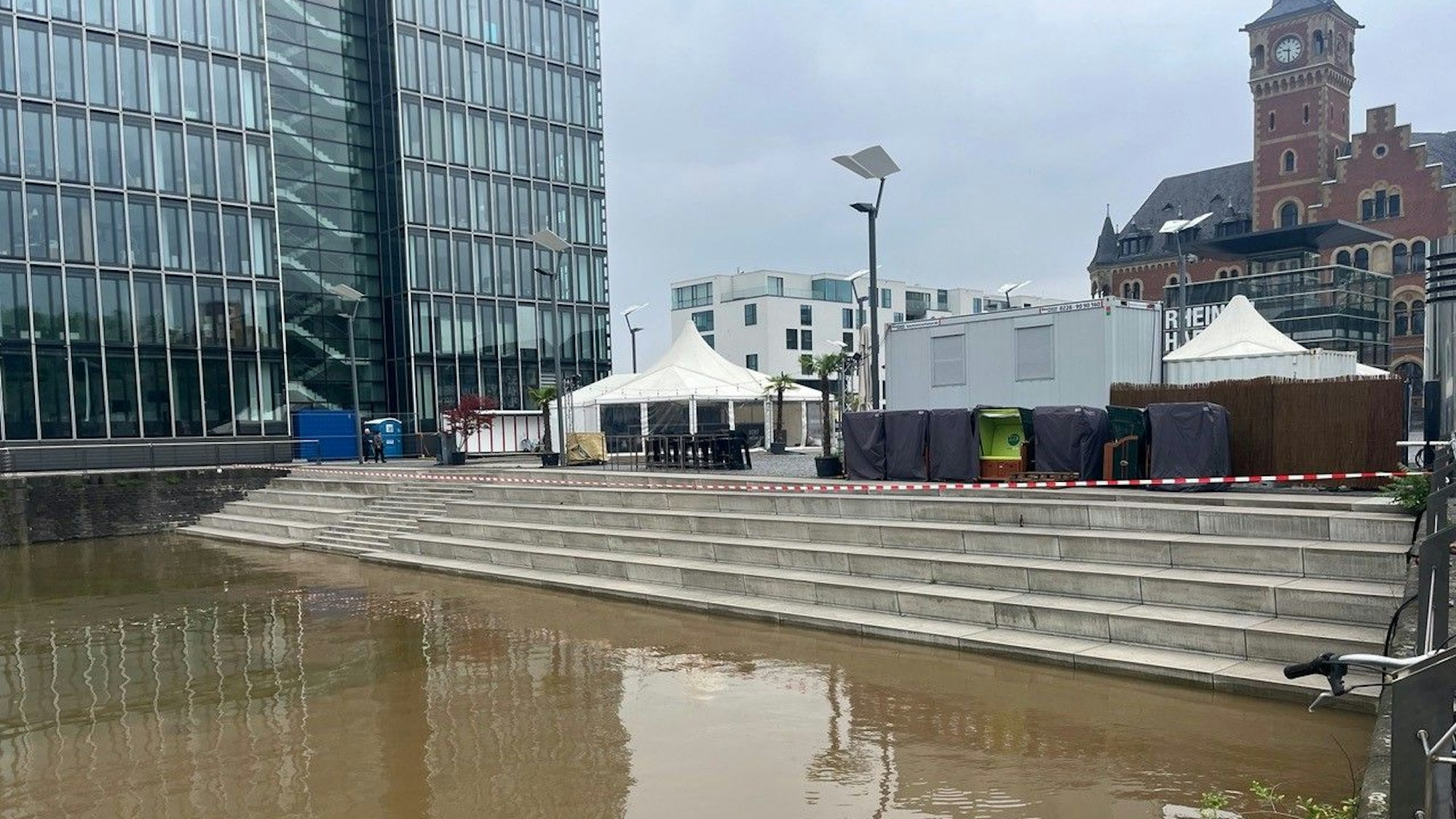 Blick auf die Tribüne im Kölner Sommerkino am Rheinauhafen. Die Treppen stehen zum Teil unter Wasser.