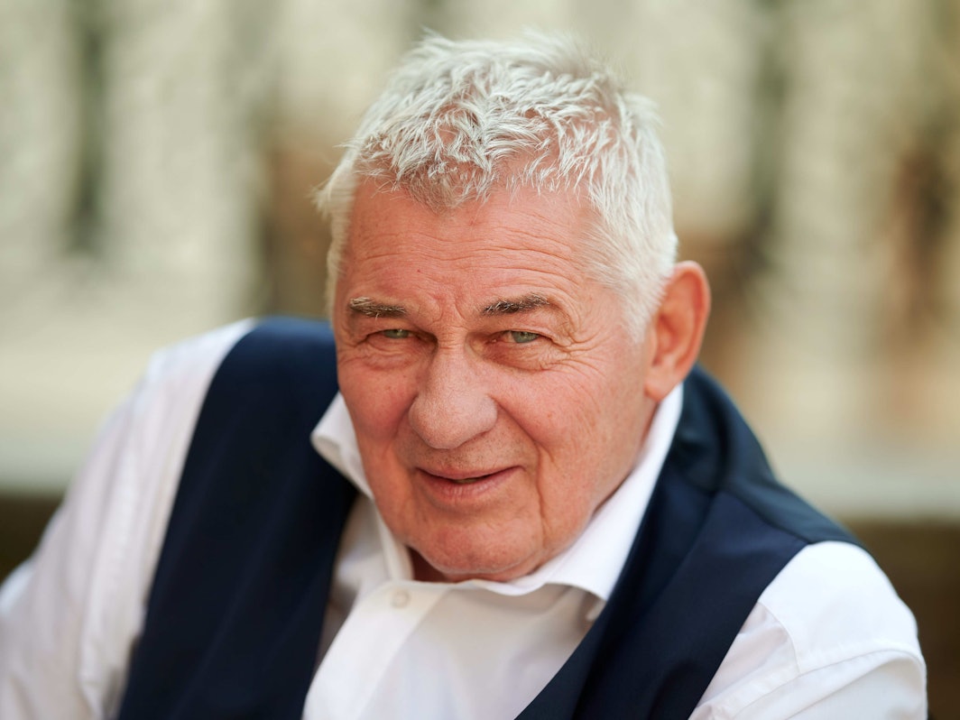 Schauspieler Heinz Hoenig sitzt bei einem Fototermin bei Dreharbeiten zur Serie „Verbotene Liebe – Next Generation“ auf einer Treppe, hier im September 2020 in NRW.