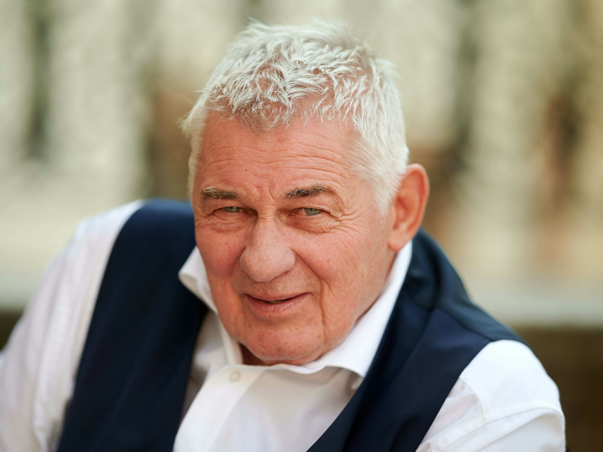 Schauspieler Heinz Hoenig sitzt bei einem Fototermin bei Dreharbeiten zur Serie „Verbotene Liebe – Next Generation“ auf einer Treppe, hier im September 2020 in NRW.