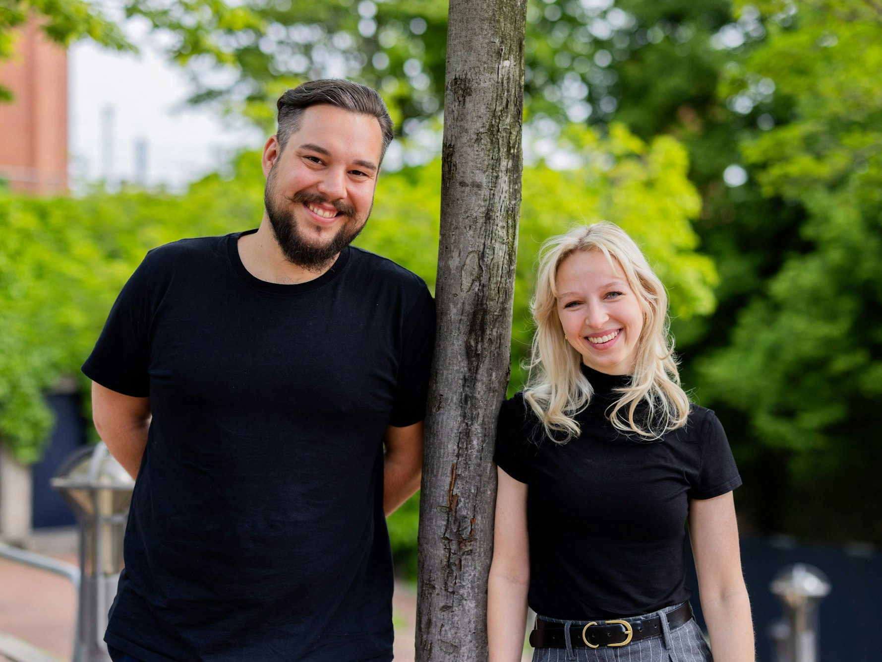 Tina Kunath und Jan Wolfenstädter stehen gemeinsam am Rheinufer in Köln und schauen in die Kamera.