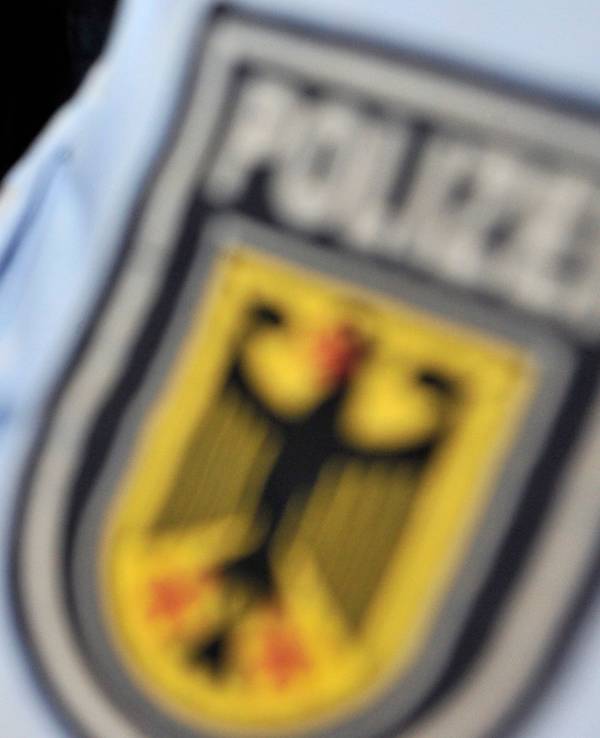 Beamte der Bundespolizei kontrollieren einen Reisepass.