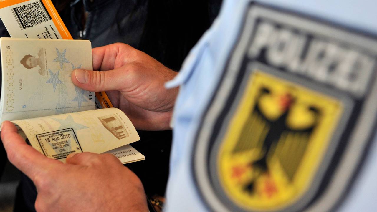Beamte der Bundespolizei kontrollieren einen Reisepass.