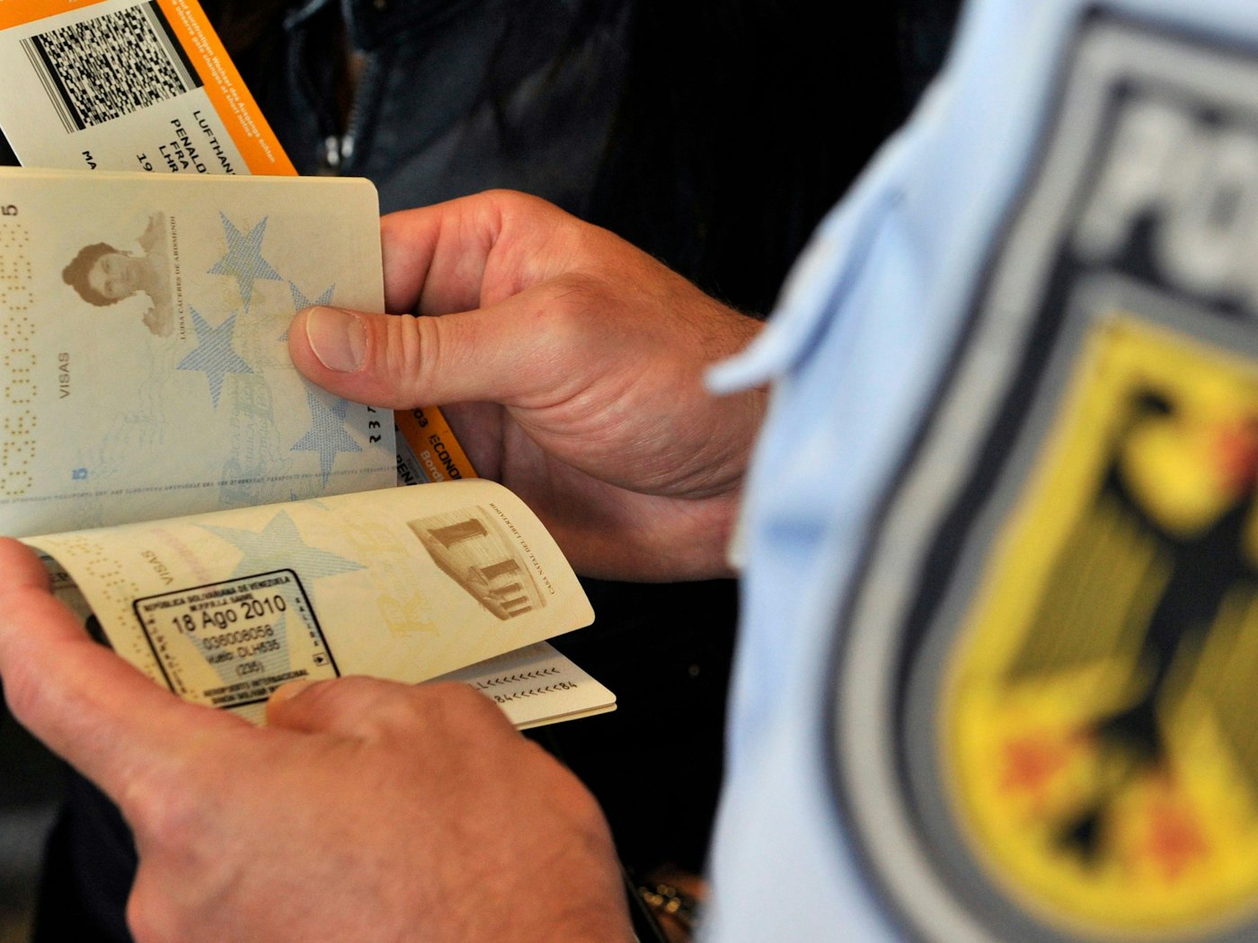 Beamte der Bundespolizei kontrollieren einen Reisepass.