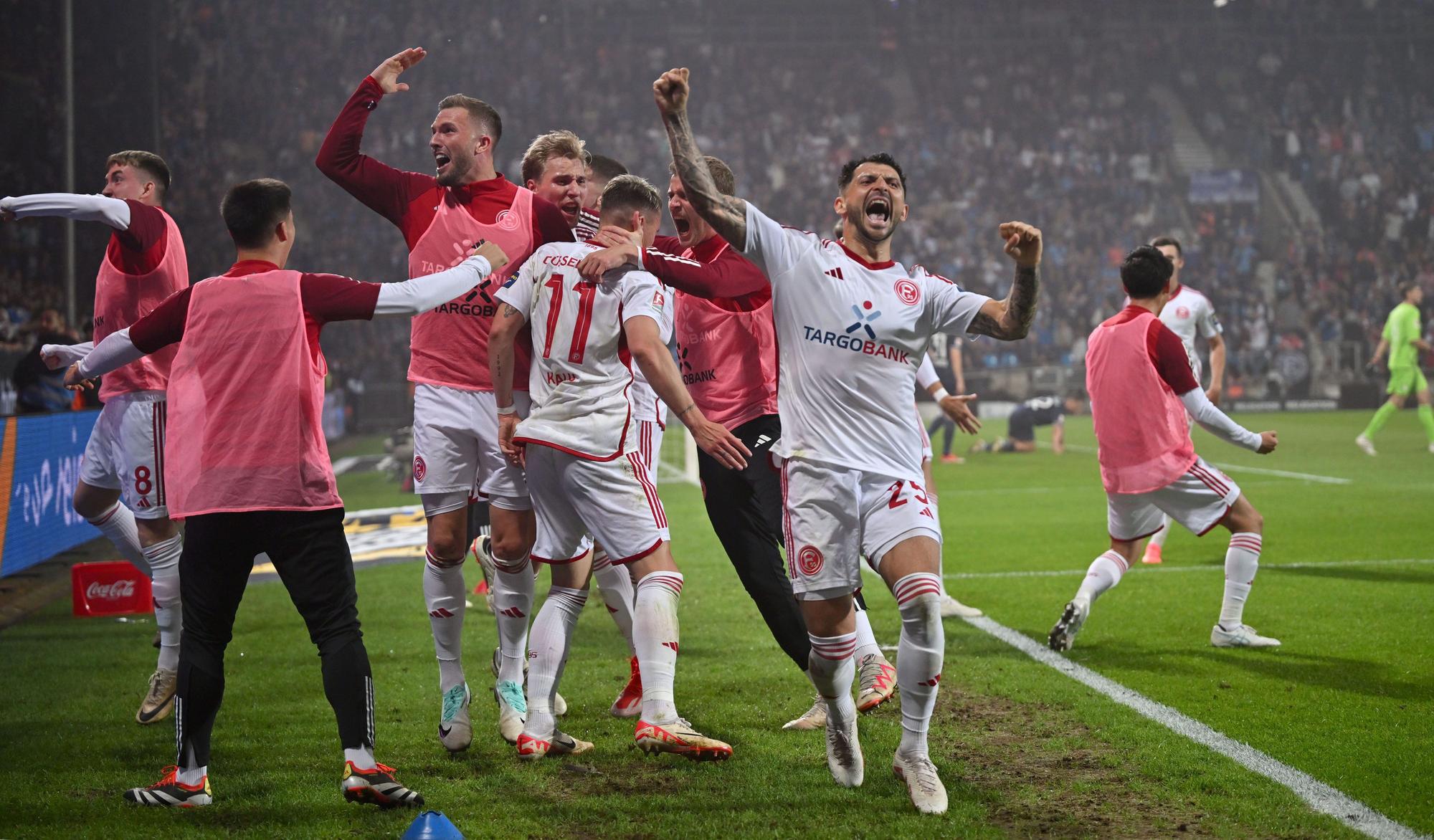 Die Spieler von Fortuna Düsseldorf jubeln an der Seitenlinie im Relegations-Hinspiel beim VfL Bochum.