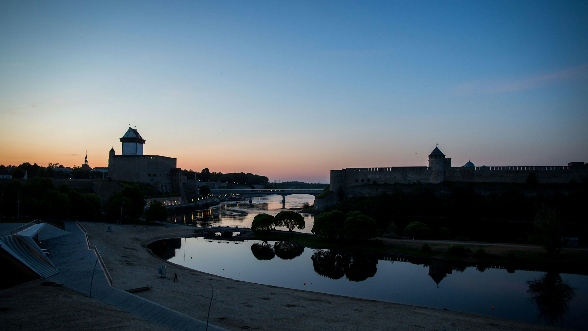 Die Sonne geht auf unserem Archivbild (2016) hinter der Hermannsfeste in der estnischen Stadt Narva und der russischen Burg Iwangorod auf der gegenüberliegenden Seite unter. Zwischen Estland und Russland fließt hier die Narva entlang. Der russische Grenzschutz entfernte Bojen aus dem Grenzfluss.