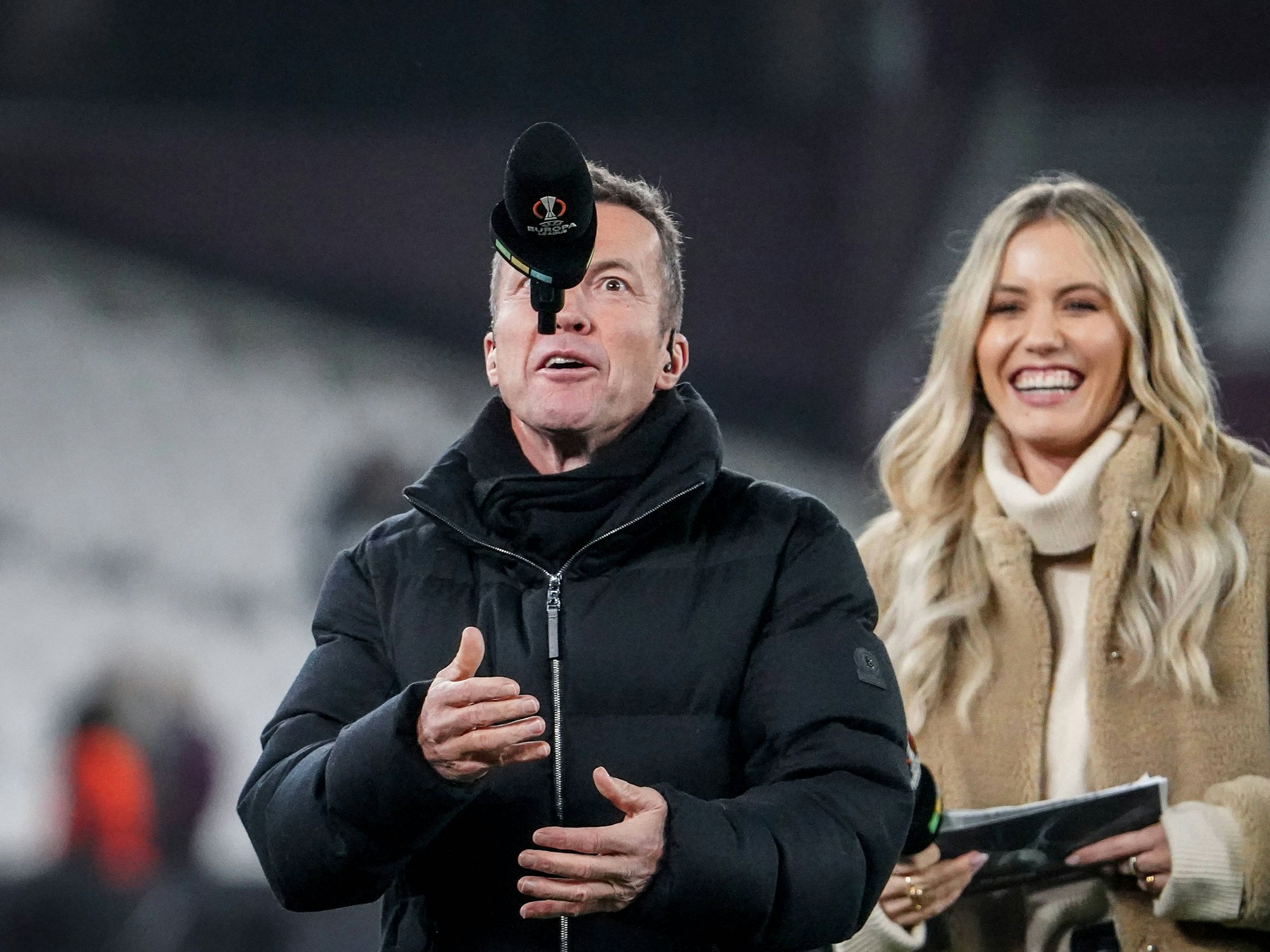 Lothar Matthäus macht Kunststücke mit seinem Mikrofon, im Hintergrund lacht Laura Papendick.