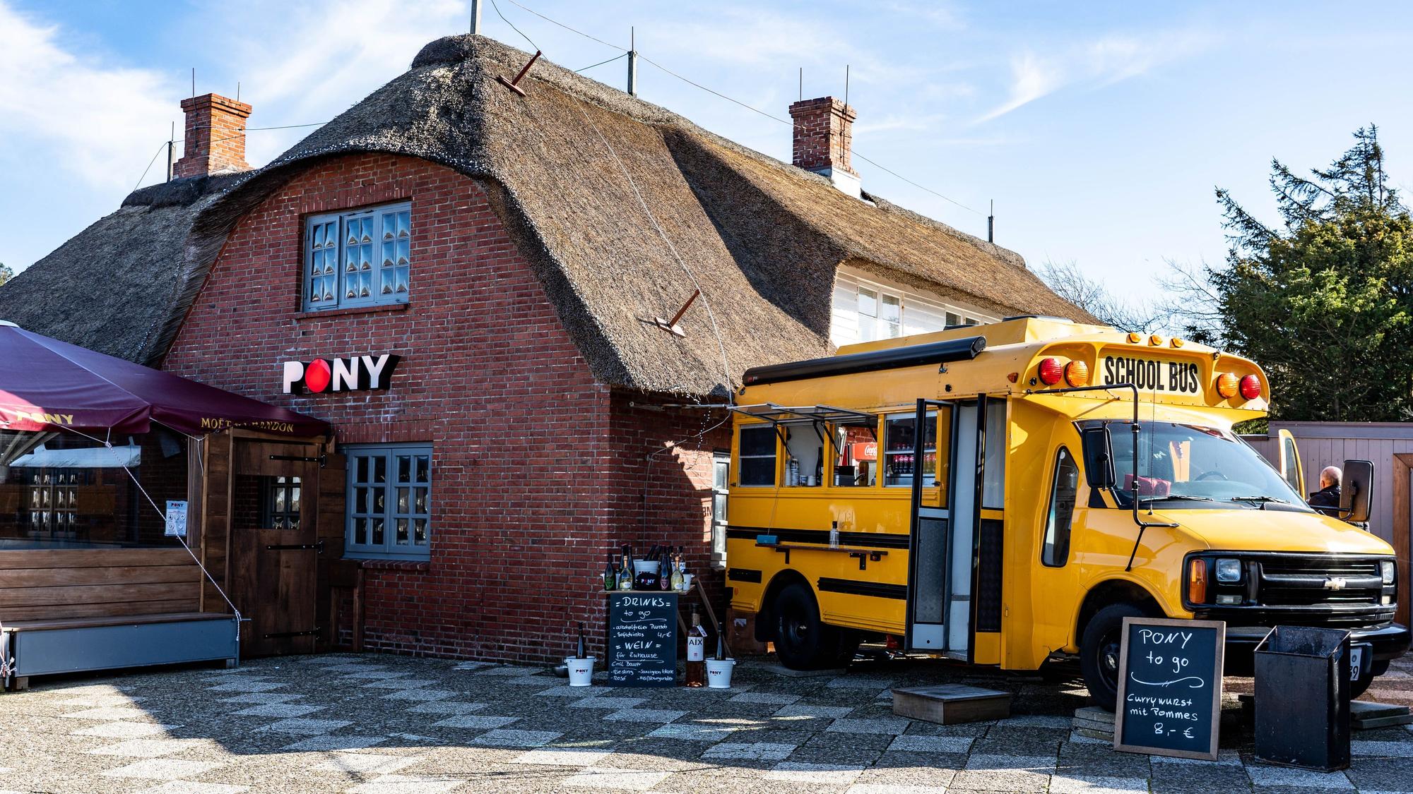 Ein alter amerikanischer Schulbus steht als Ausschank neben der Gaststätte „Pony“ in der Straße Strönwai im Zentrum von Kampen. (Illustration zu "Empörung nach Video mit rassistischem Gegröle - Sylter Lokal betroffen") +++ dpa-Bildfunk +++