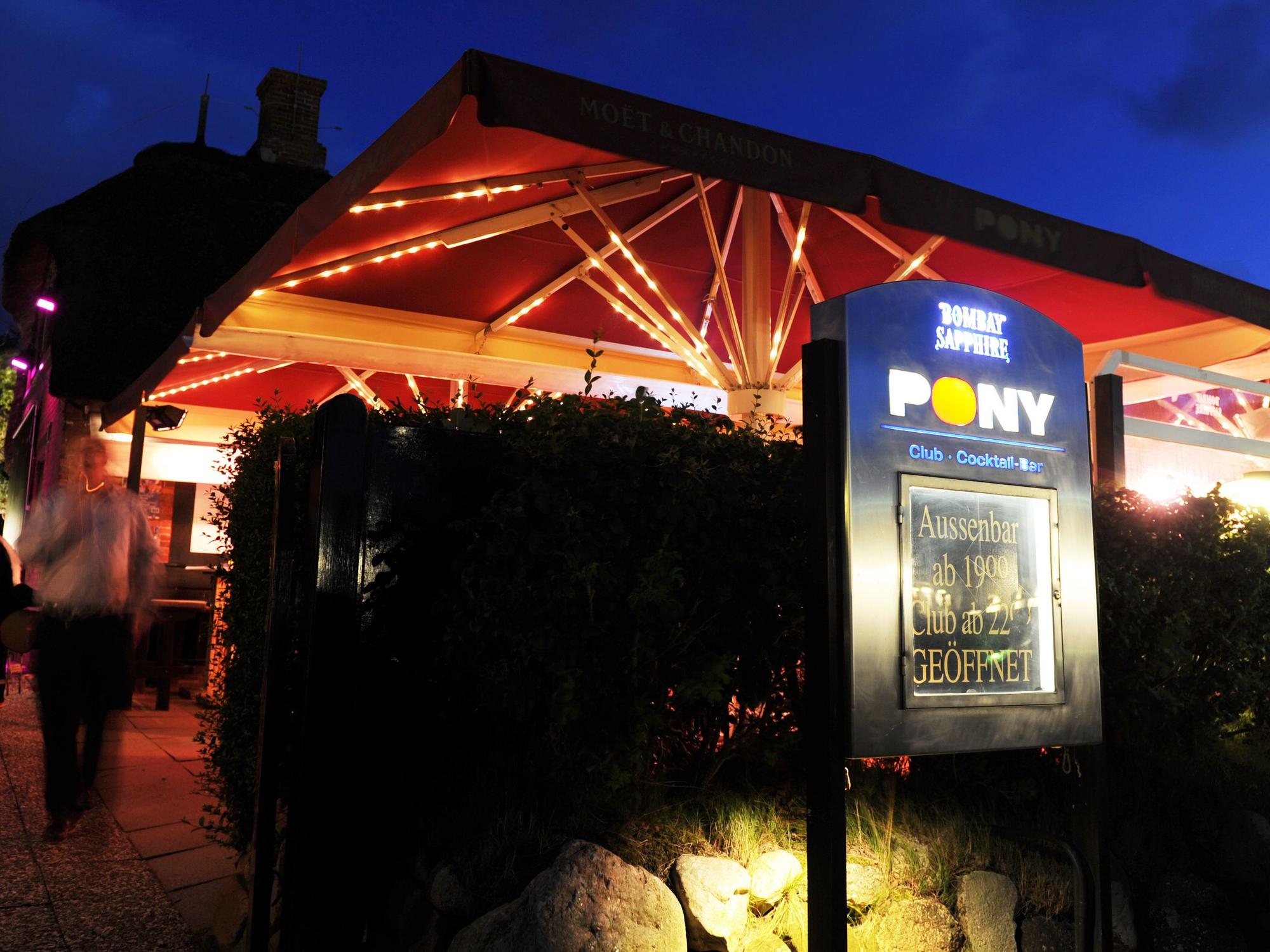 Passanten gehen am 15.07.2011 in Kampen auf der Nordseeinsel Sylt an der Pony-Bar vorbei. Seit 50 Jahren wird in der Edelbar und Promidisco gefeiert.