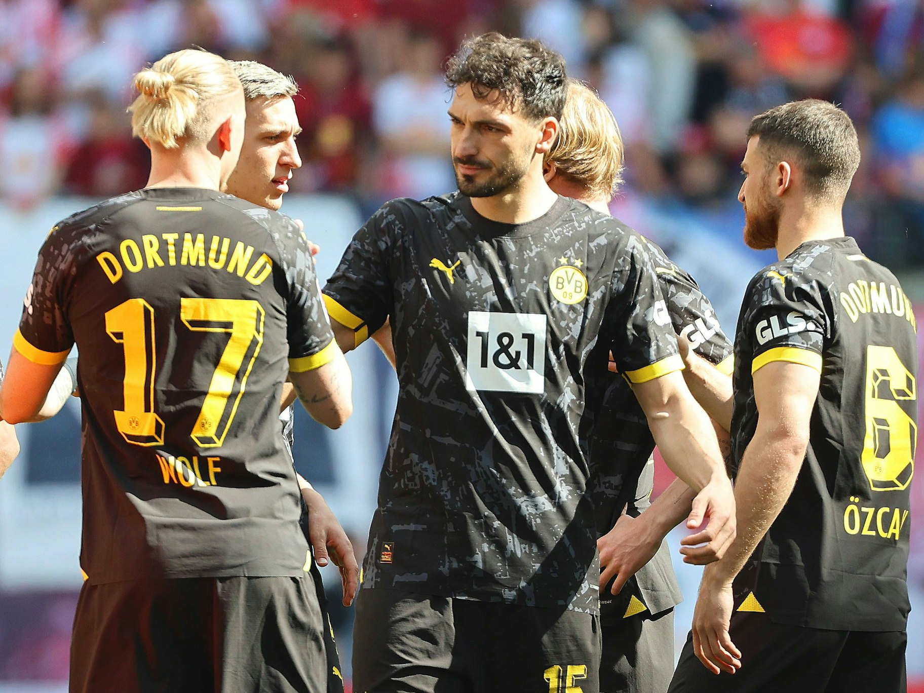 Marius Wolf (l.), Mats Hummels (M.) und Salih Özcan klatschen sich ab.