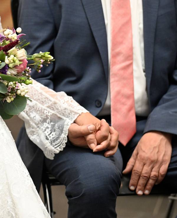 Hochzeitspaar hält sich an den Händen