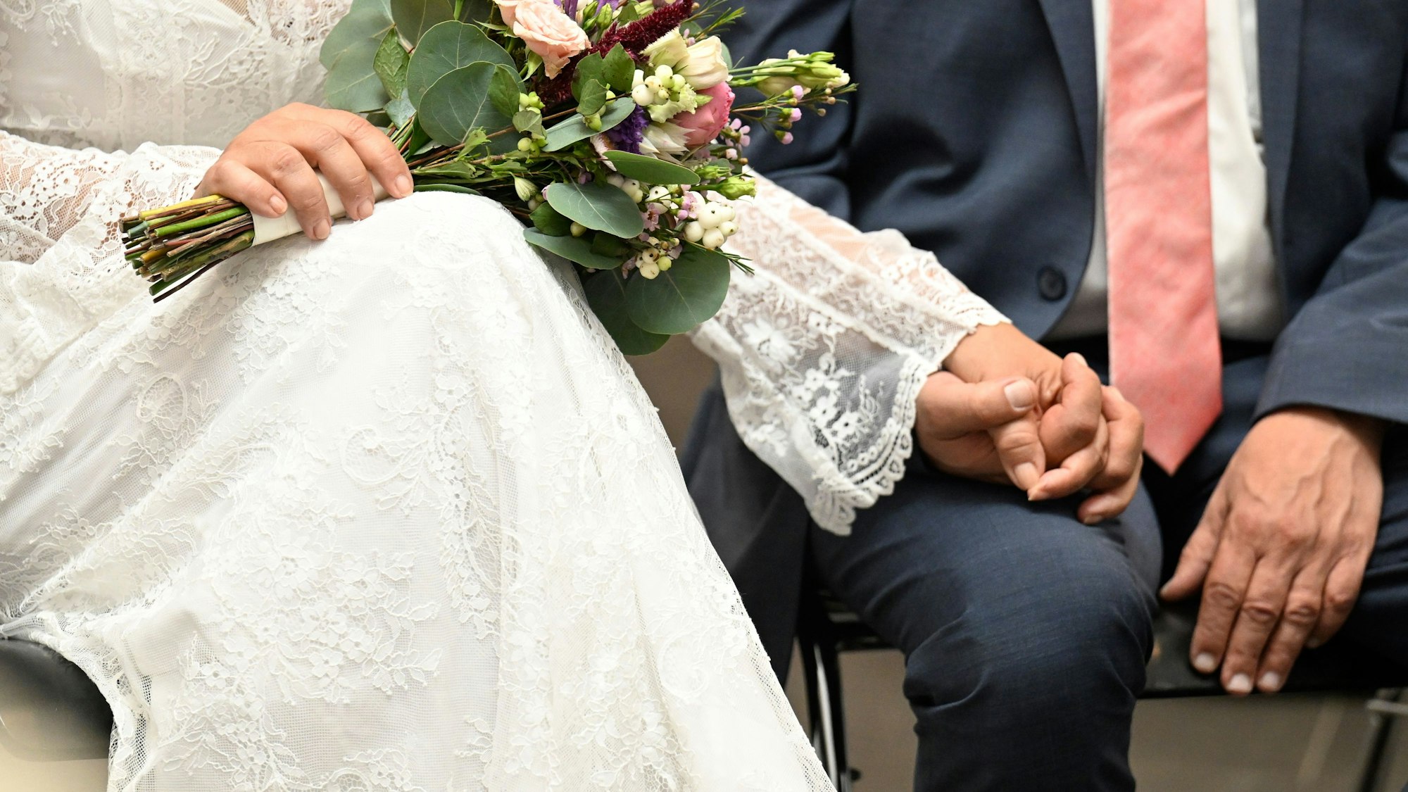 Hochzeitspaar hält sich an den Händen