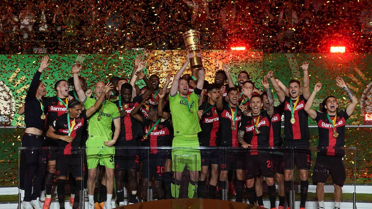 Der Kapitän von Bayer Leverkusen, Lukas Hradecky, hebt umringt von seinen Teamkollegen den DFB-Pokal in die Höhe.