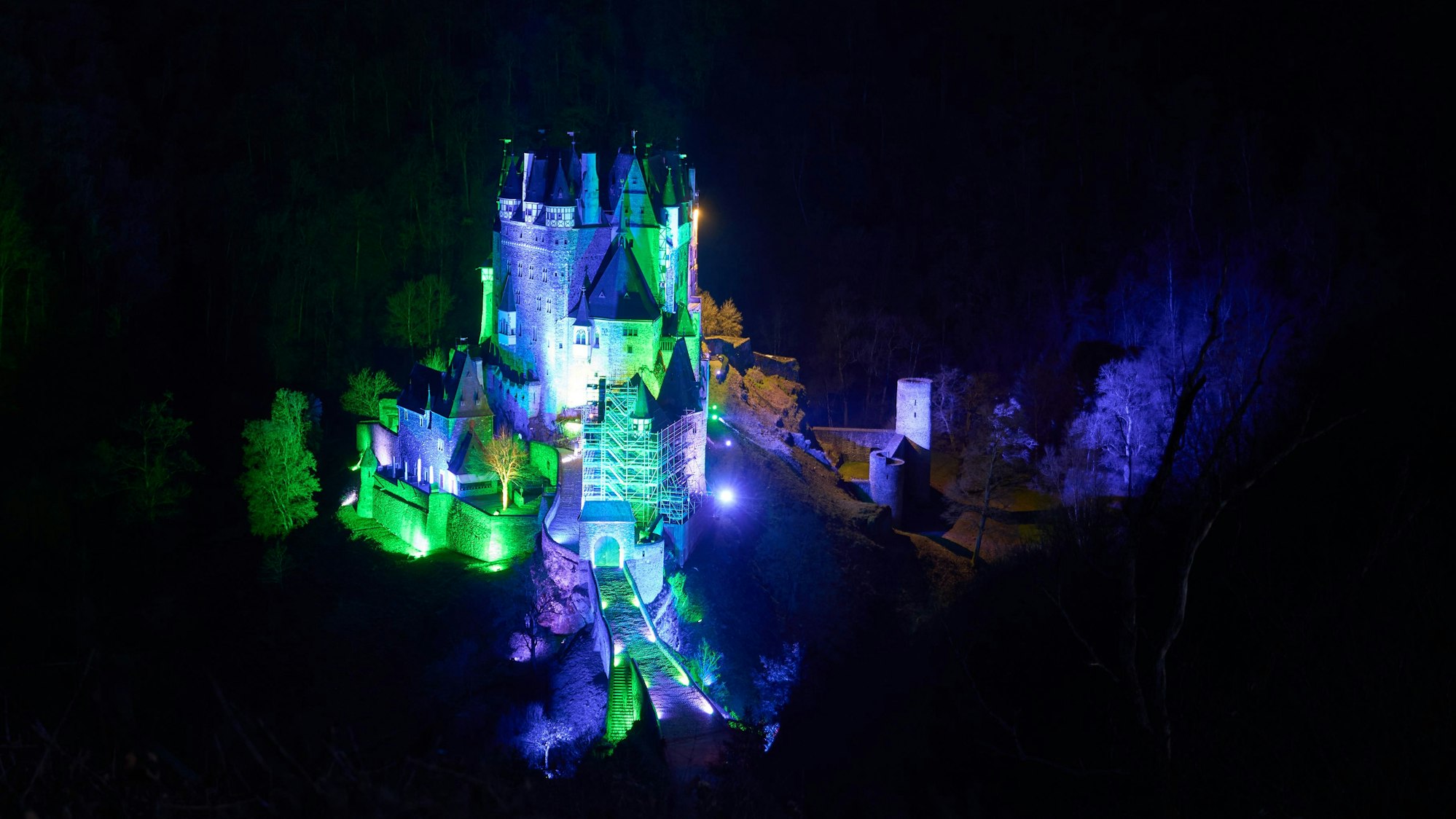 Burg Eltz erstrahlt in farbigem Licht.