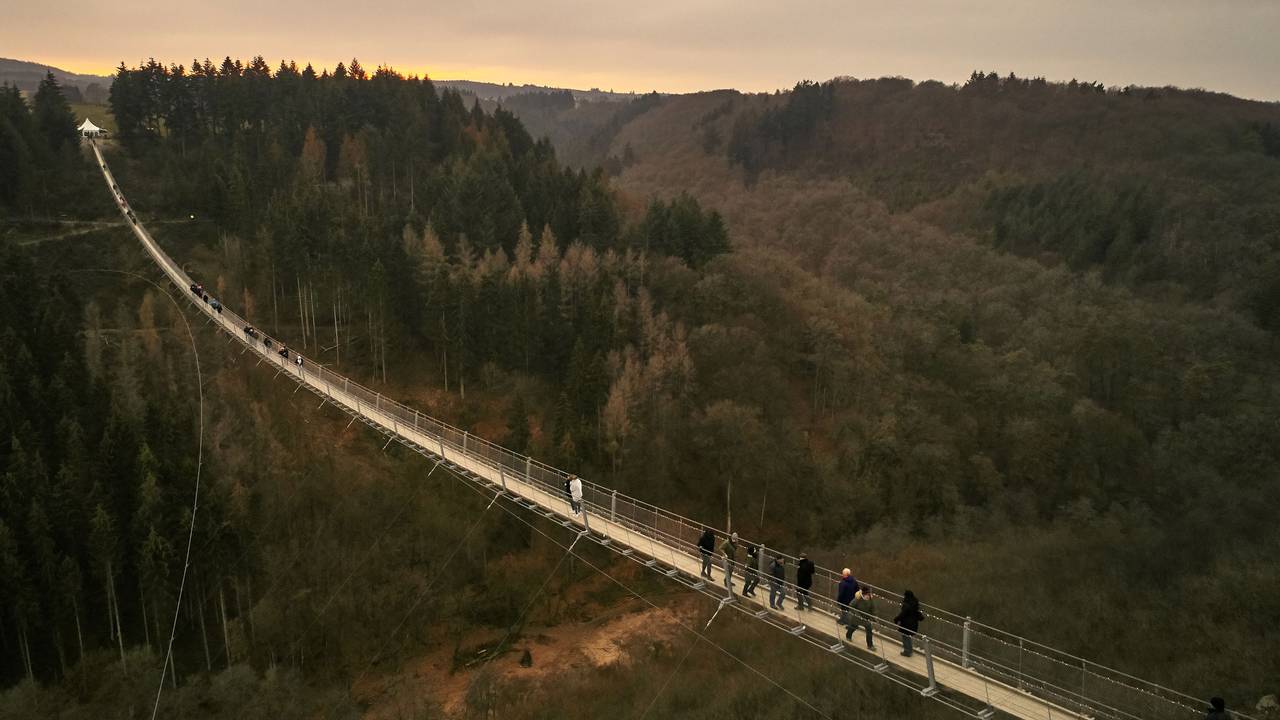 Besucher gehen auf der Hängeseilbrücke Geierlay hoch über einem Mosel-Seitental bei Mörsdorf im Hunsrück