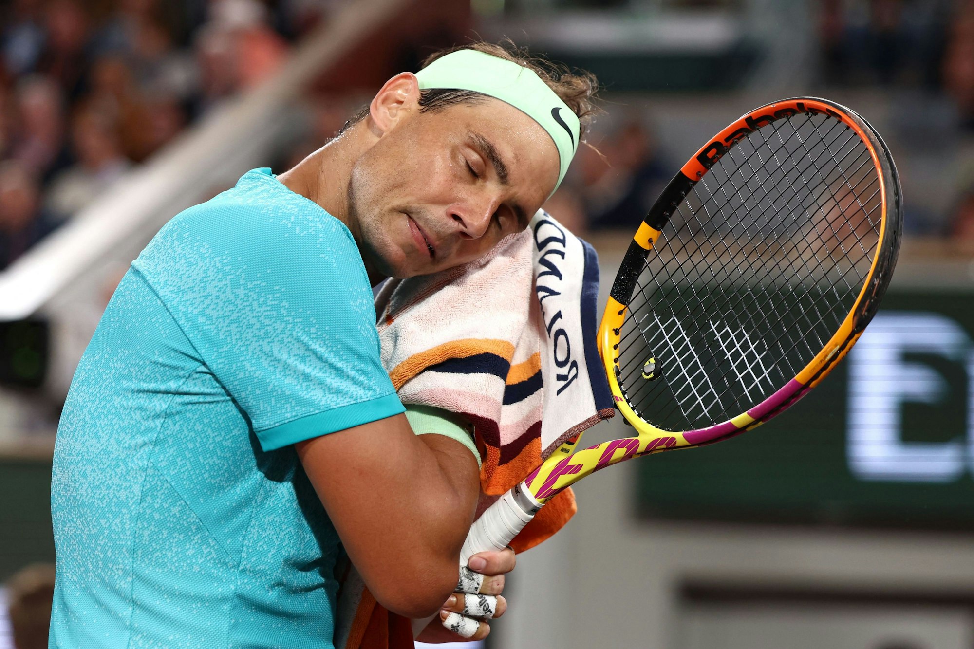 Rafael Nadal wischt sich mit einem Handtuch den Schweiß ab.