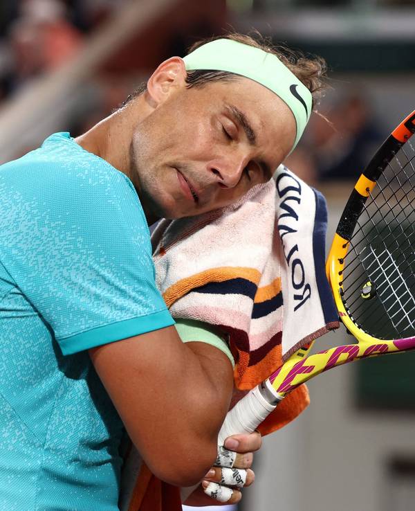 Rafael Nadal wischt sich mit einem Handtuch den Schweiß ab.