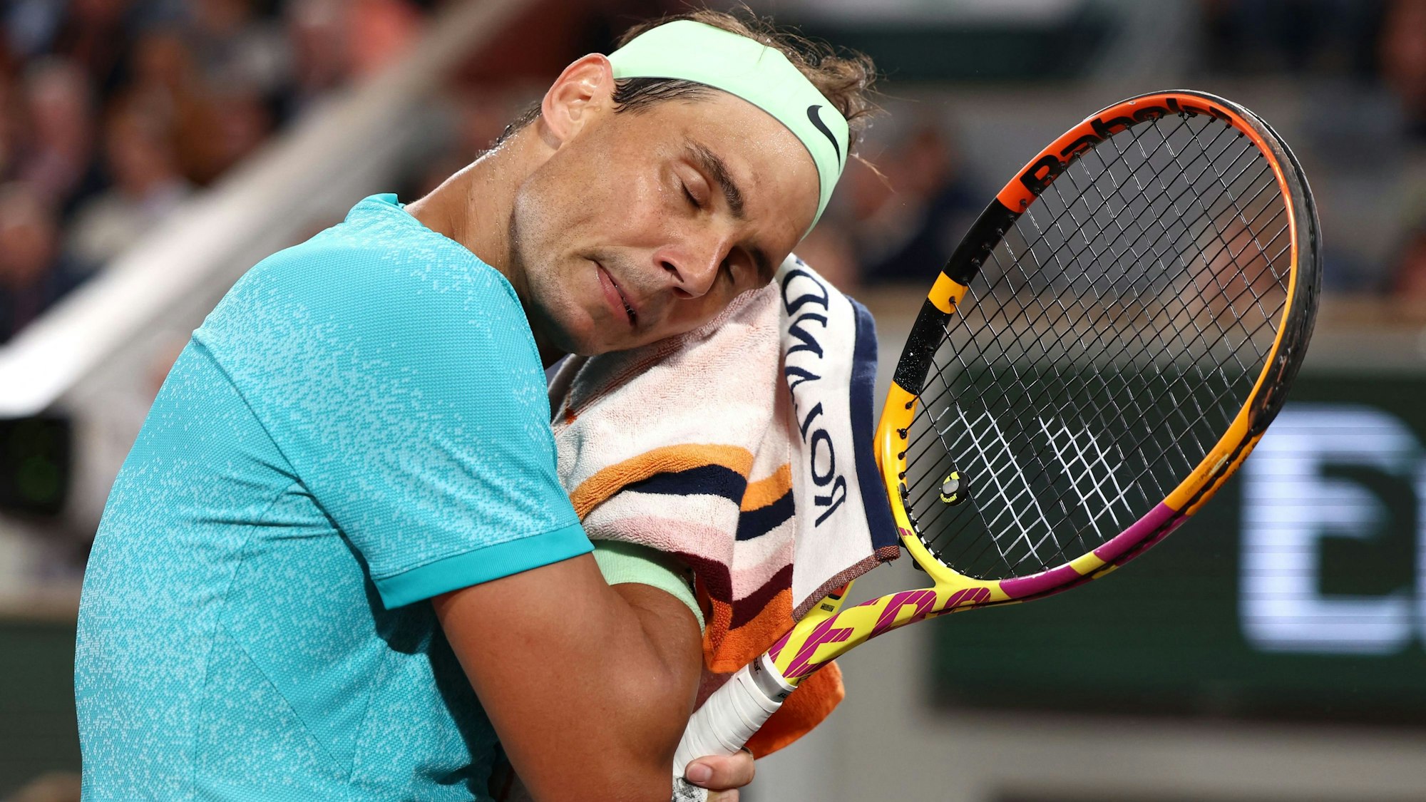 Rafael Nadal wischt sich mit einem Handtuch den Schweiß ab.