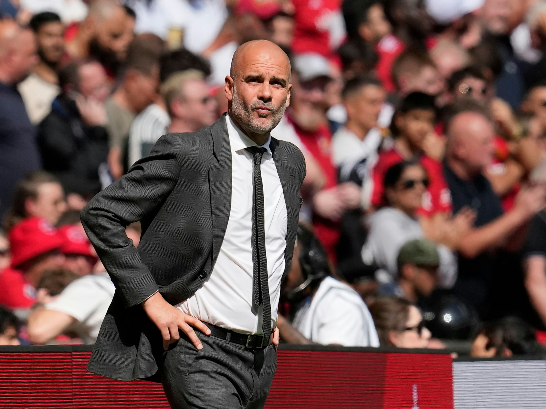 Pep Guardiola im Anzug an der Seitenlinie.