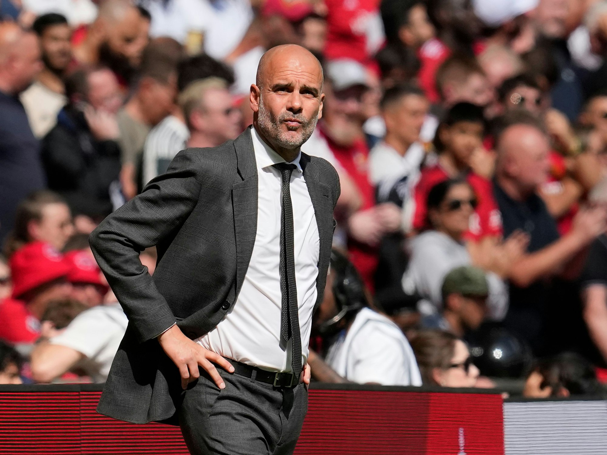 Pep Guardiola im Anzug an der Seitenlinie.