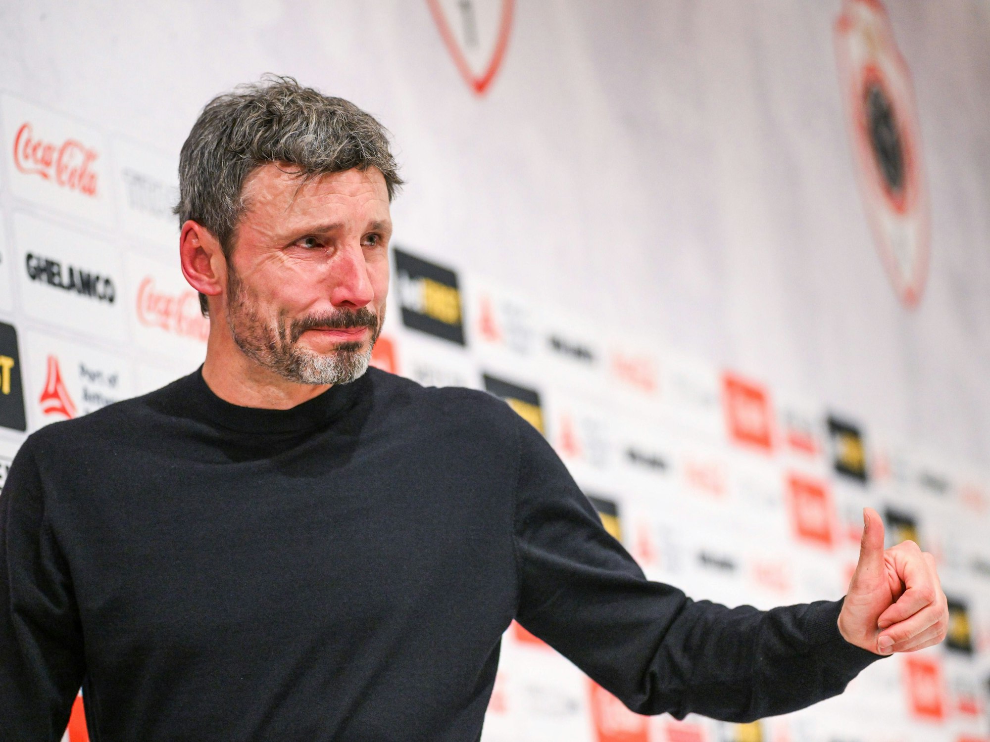 Mark van Bommel zeigt bei seiner letzten Pressekonferenz unter Tränen den Journalisten den Daumen nach oben.