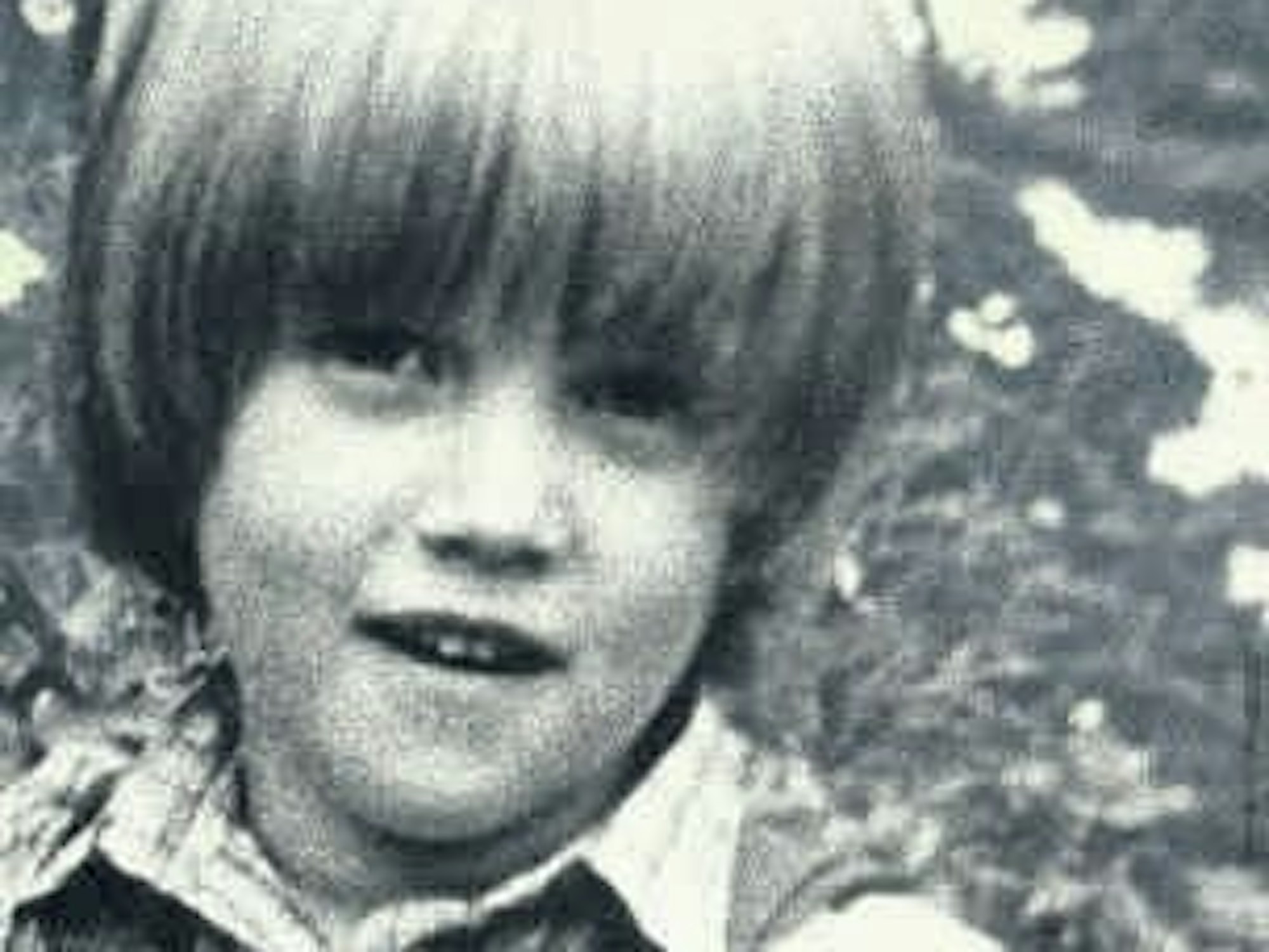 Ein kleiner Junge wurde auf einer Wiese fotografiert.