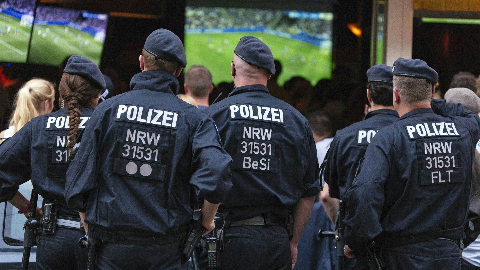 Polizeikräfte beobachten das Public Viewing vor einer Kölner Kneipe.