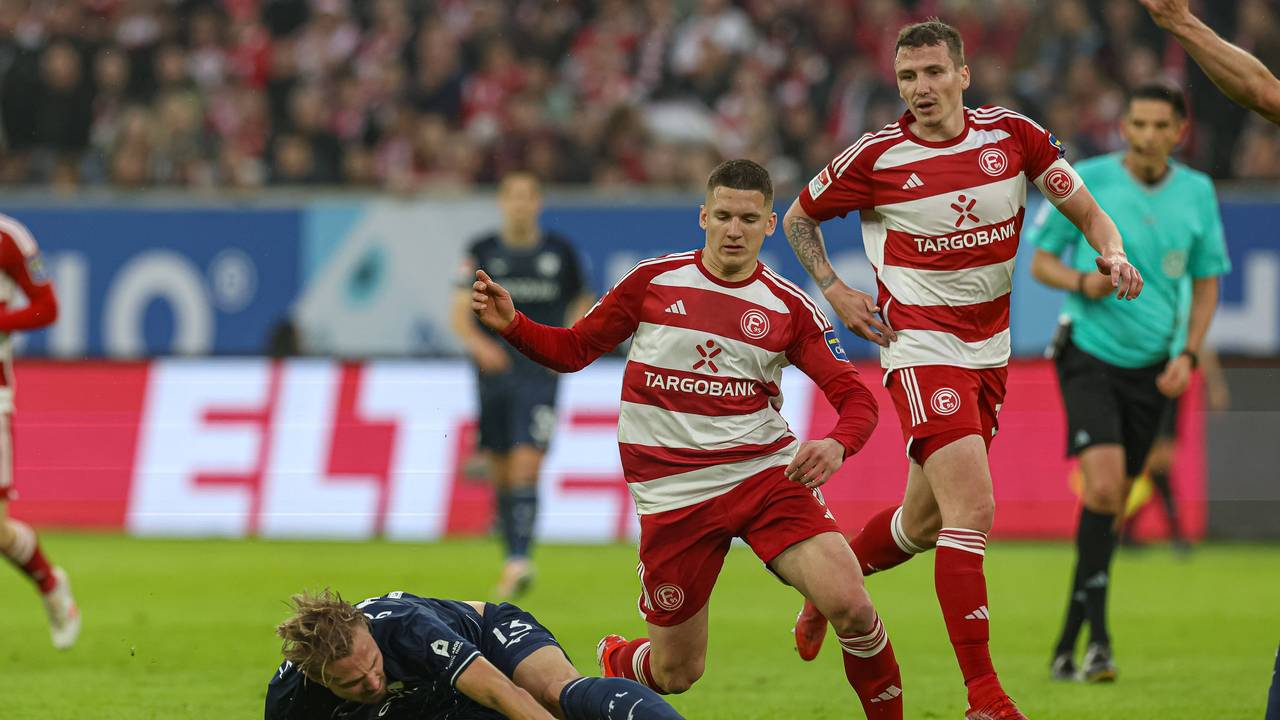 Fortuna Düsseldorfs Christo Tzolis kämpft mit Bochums Lukas Daschner um den Ball. Marcel Sobottka beobachtet die Szene aus dem Hintergrund.