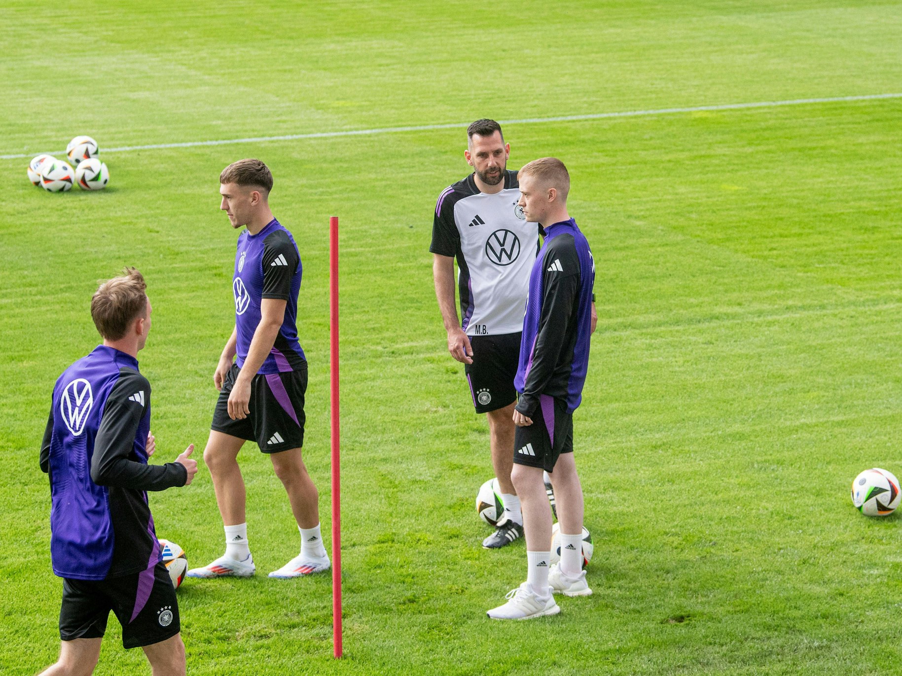 Der YouTuber Marvin Wildhage spricht beim DFB-Training mit Standardtrainer Mads Buttgereit. Links daneben trainieren Maximilian Beier und Brajan Gruda.