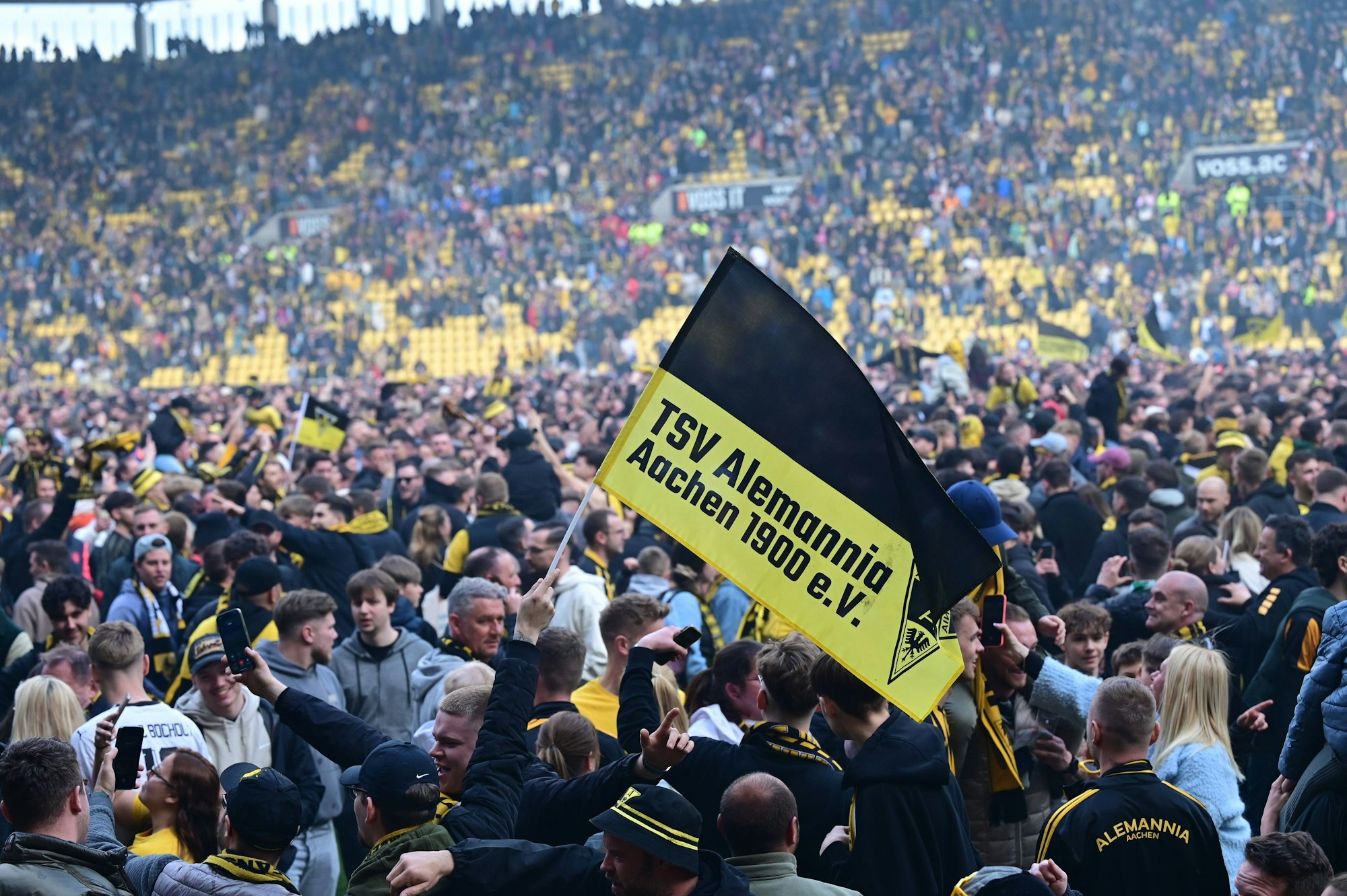 Fans von Alemannia Aachen feiern den Drittliga-Aufstieg mit einem Platzsturm.
