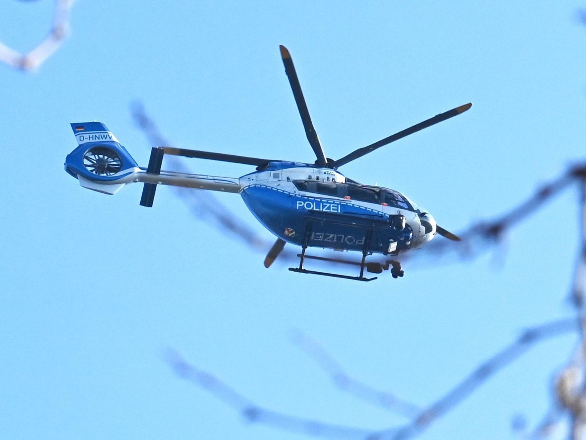 Ein Polizeihubschrauber kreist in der Luft.