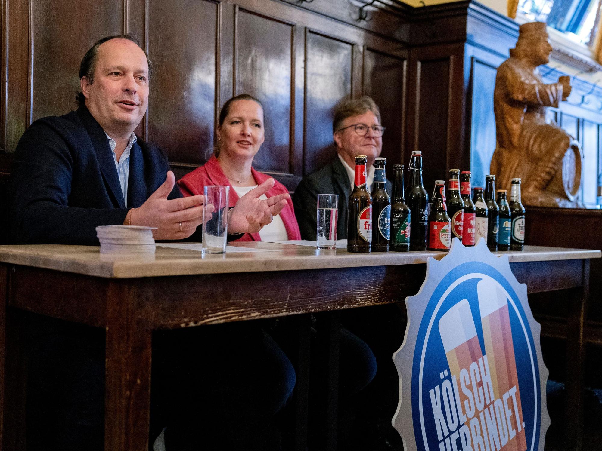 Heinrich Philipp Becker, Melanie Schwartz und Alexander Rolff an einem Pult in einer Kölner Brauerei.