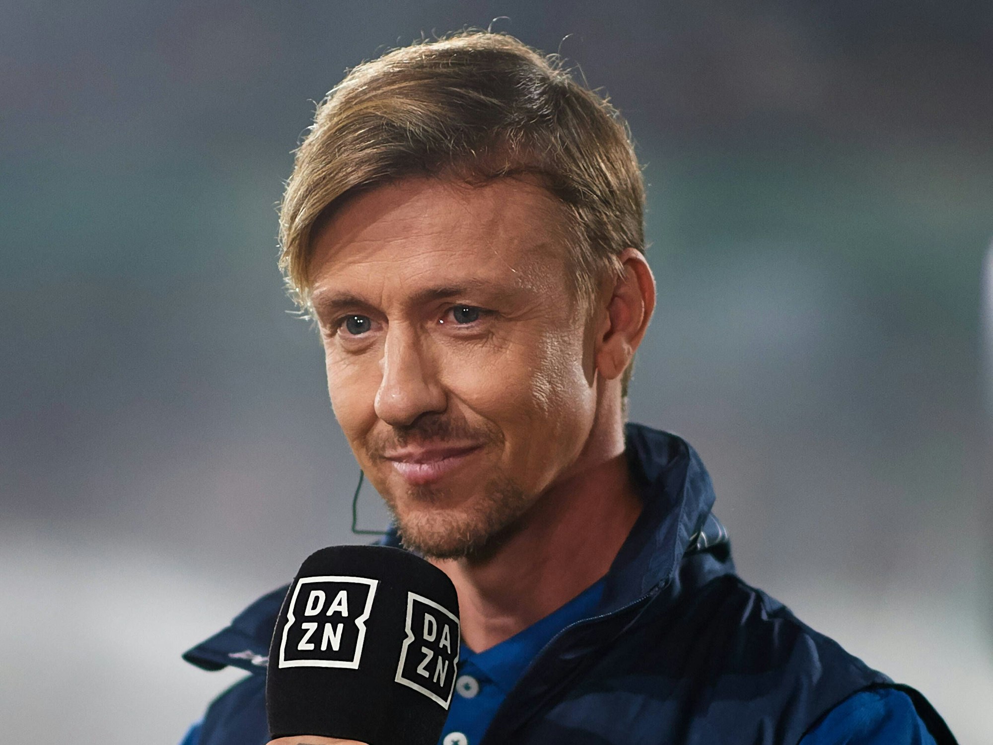 Guti hält ein DAZN-Mikrofon in der Hand.