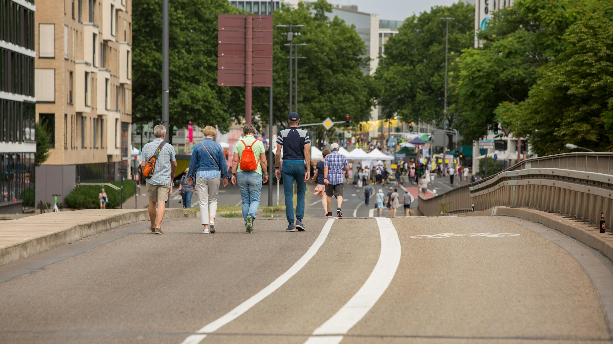 Menschen gehen während des Strassenland-Festivals über die leere Nord-Süd-Fahrt in Köln.