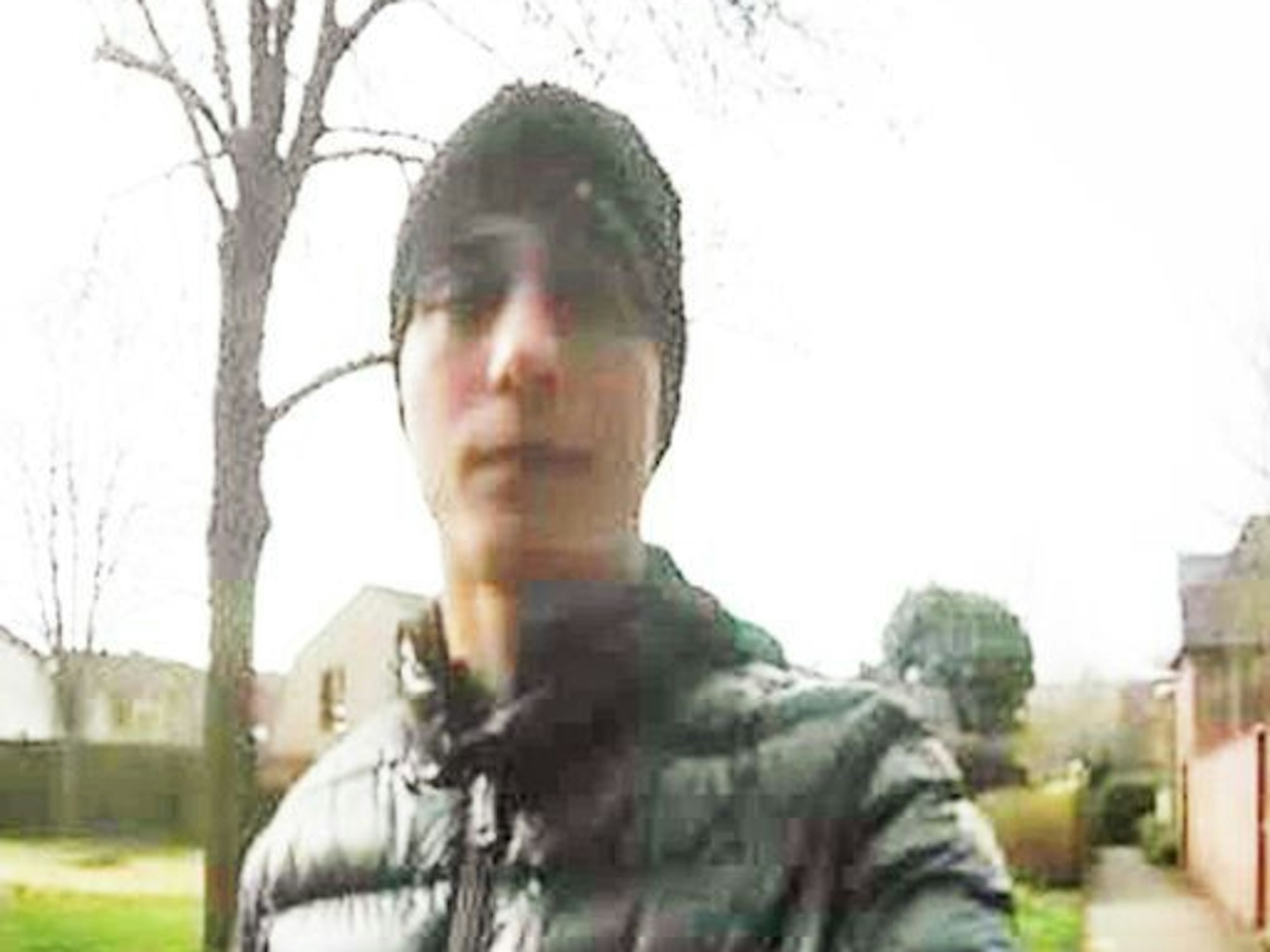 Szene aus einer Überwachungskamera, ein junger Mann klingelt an einer Haustür.