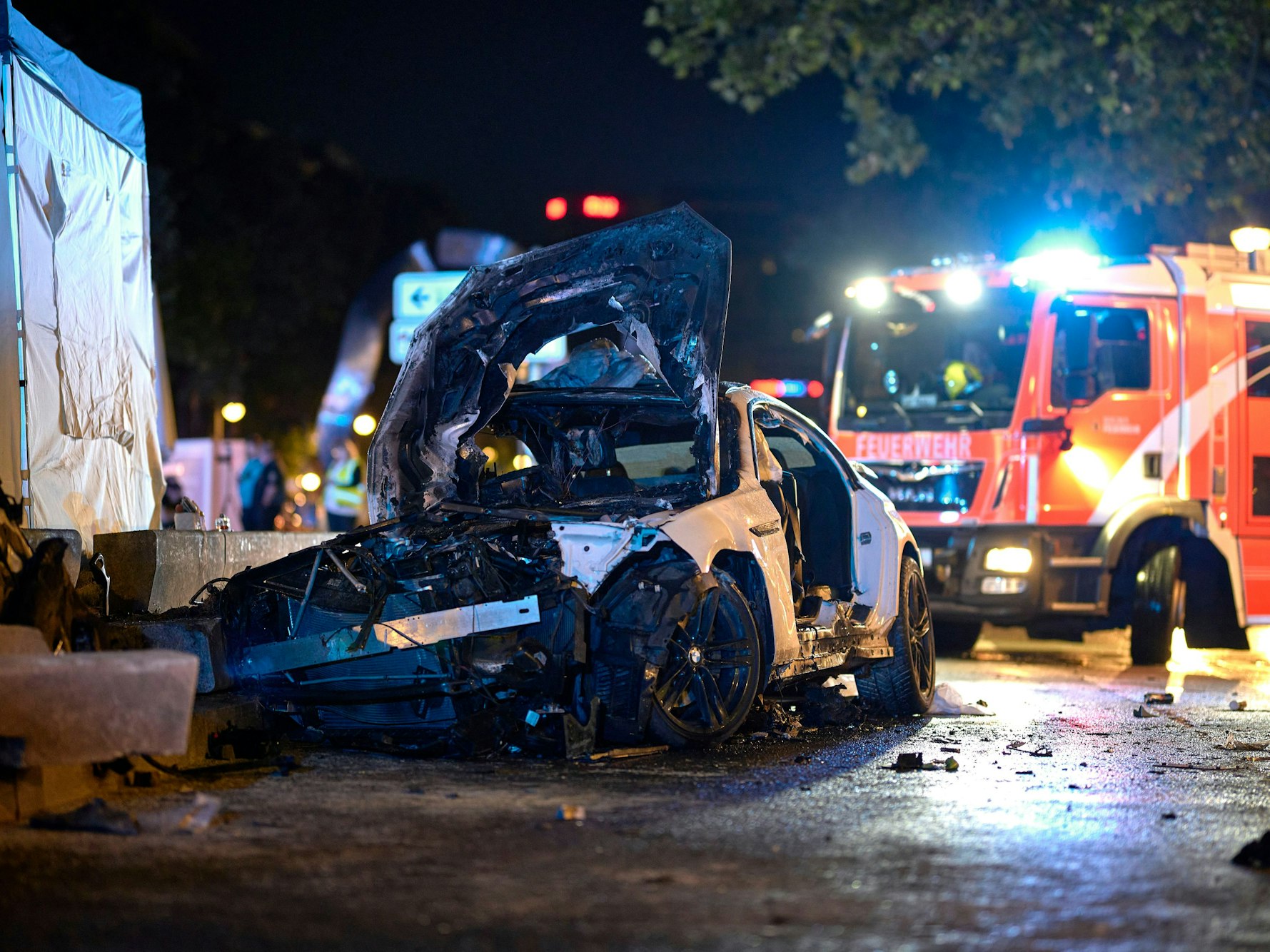 Das Wrack eines Autos steht nach einem Unfall am Mittwoch (29. Mai 2024) vor einem Fahrzeug der Feuerwehr. Ein Mensch ist bei einem Autounfall in Berlin-Charlottenburg in seinem Wagen gestorben, drei weitere sind teils lebensgefährlich verletzt worden.